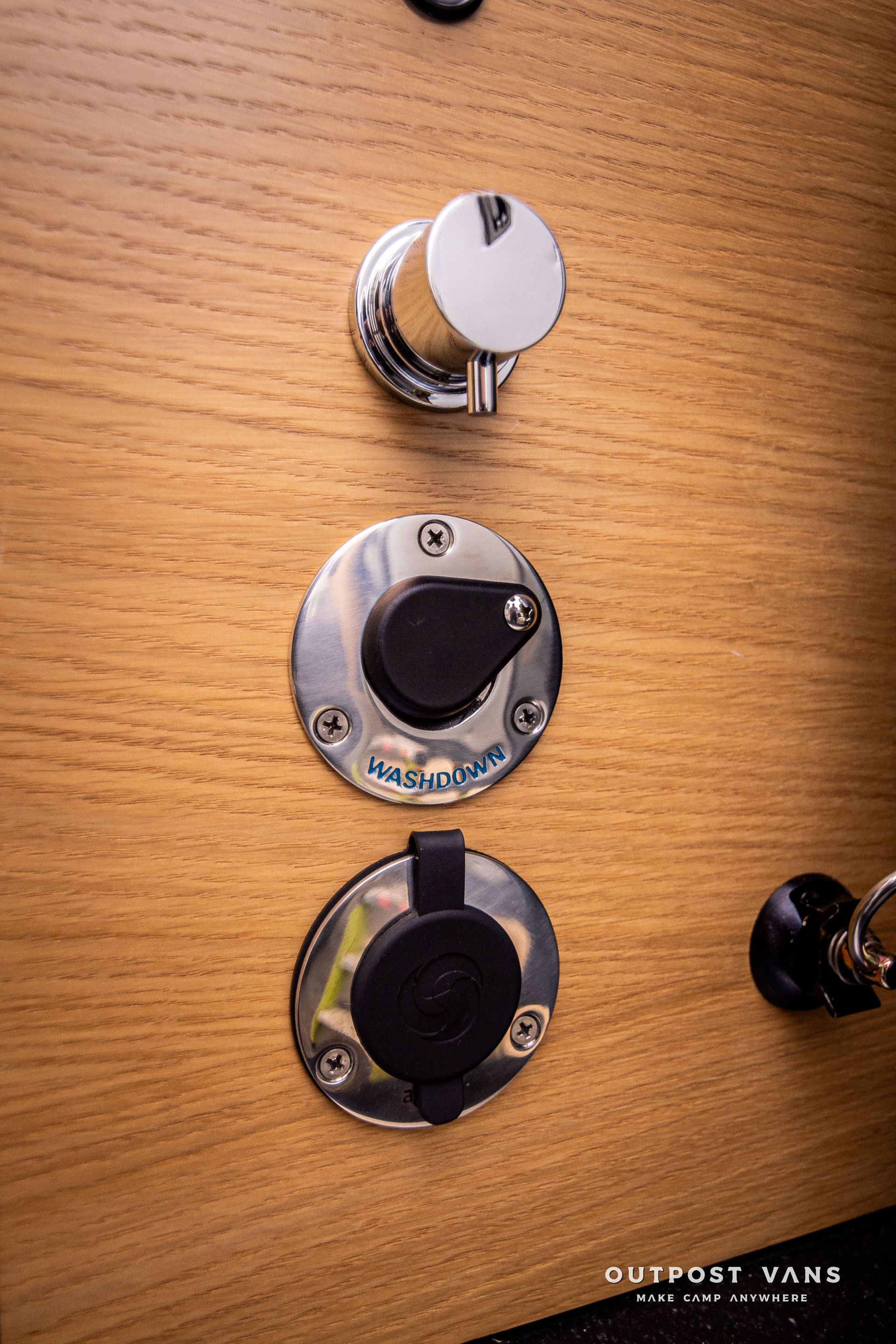 A close up of a wooden wall with a bunch of electrical outlets on it.
