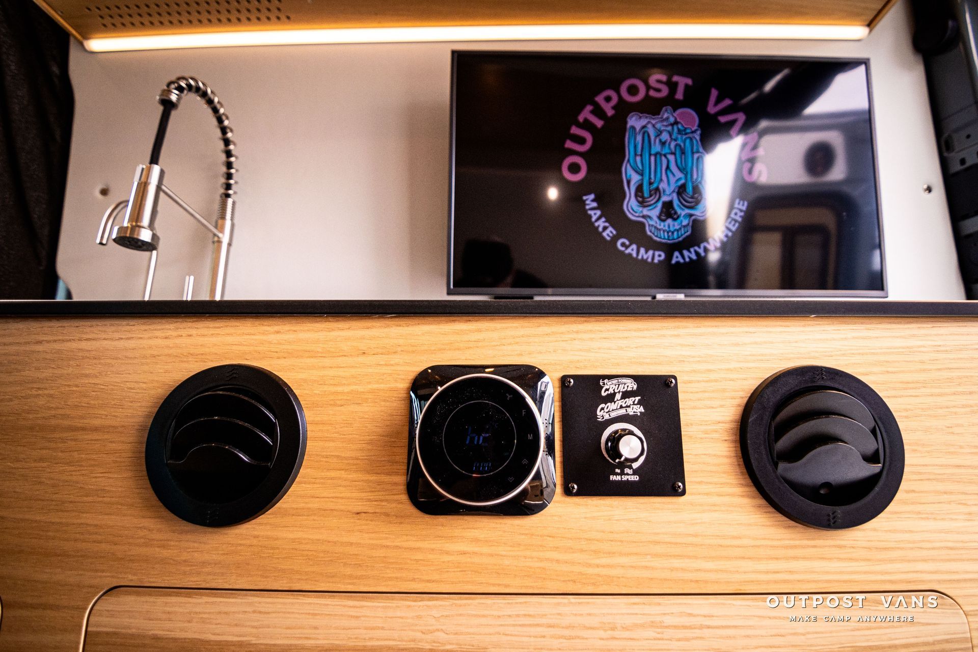 A kitchen with a flat screen tv and a sink.