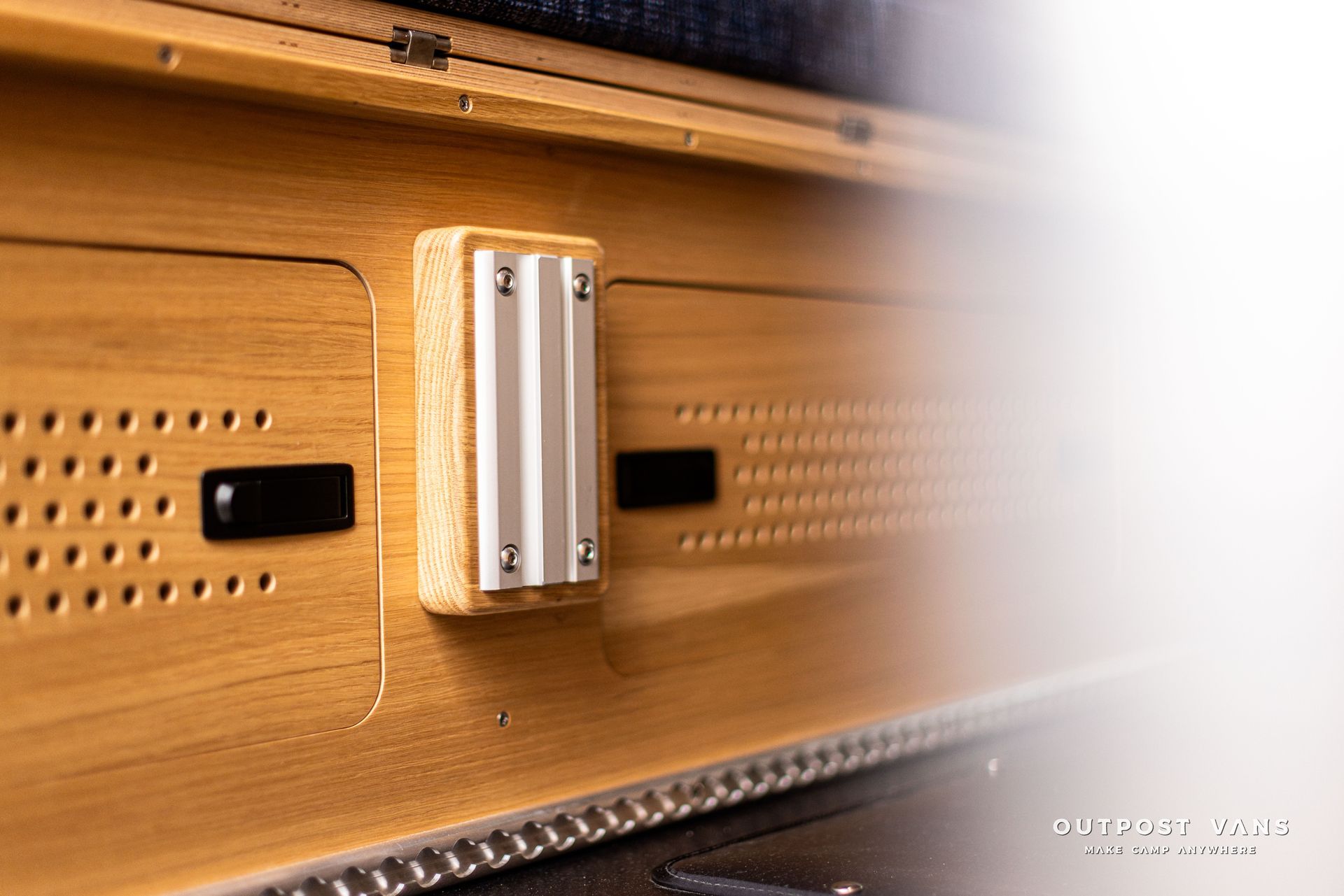 A close up of a wooden box with a button on it.