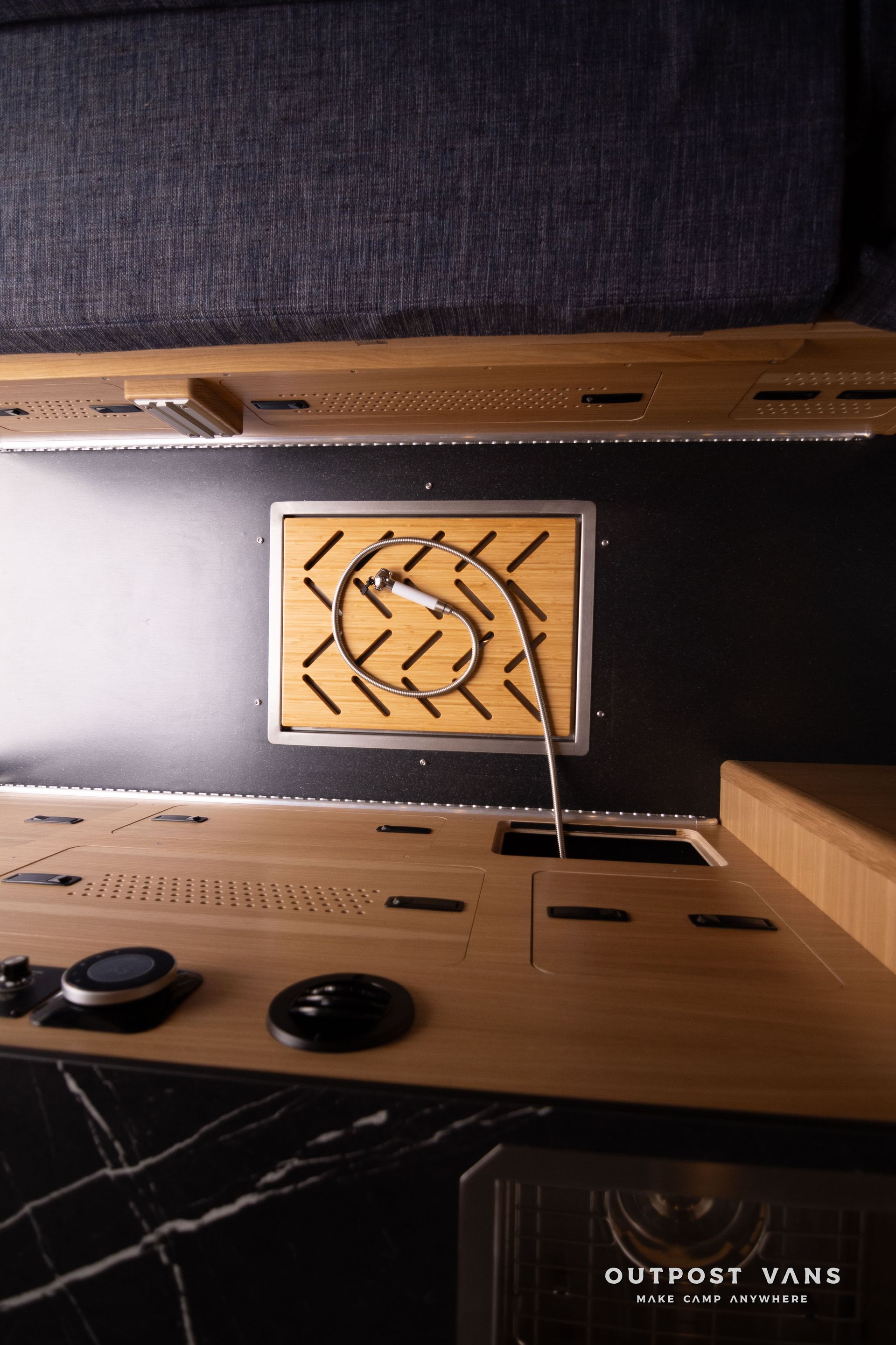 A kitchen with a sink , stove and a picture on the wall.