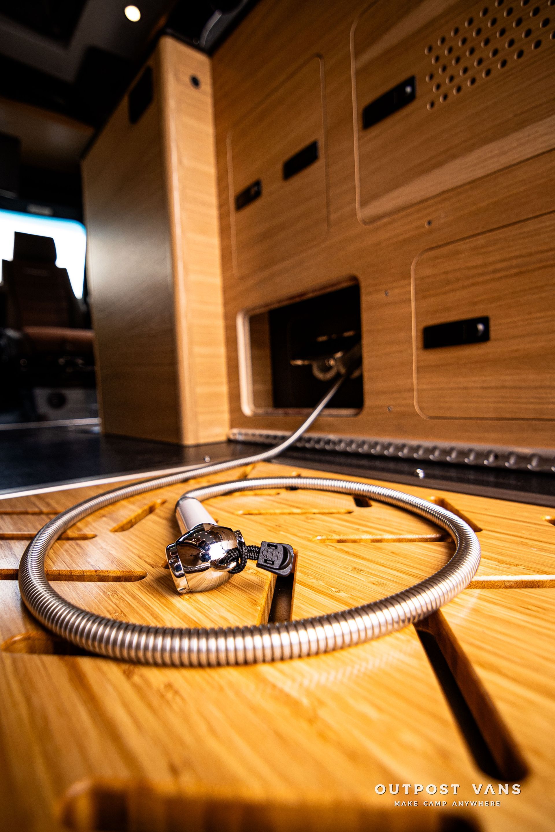 A hose is laying on a wooden floor in a van.