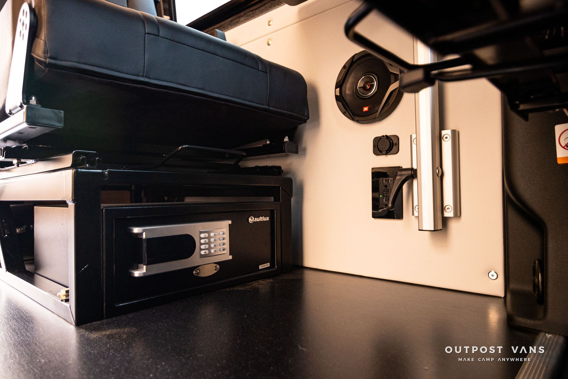 A safe is sitting under a seat in a vehicle.