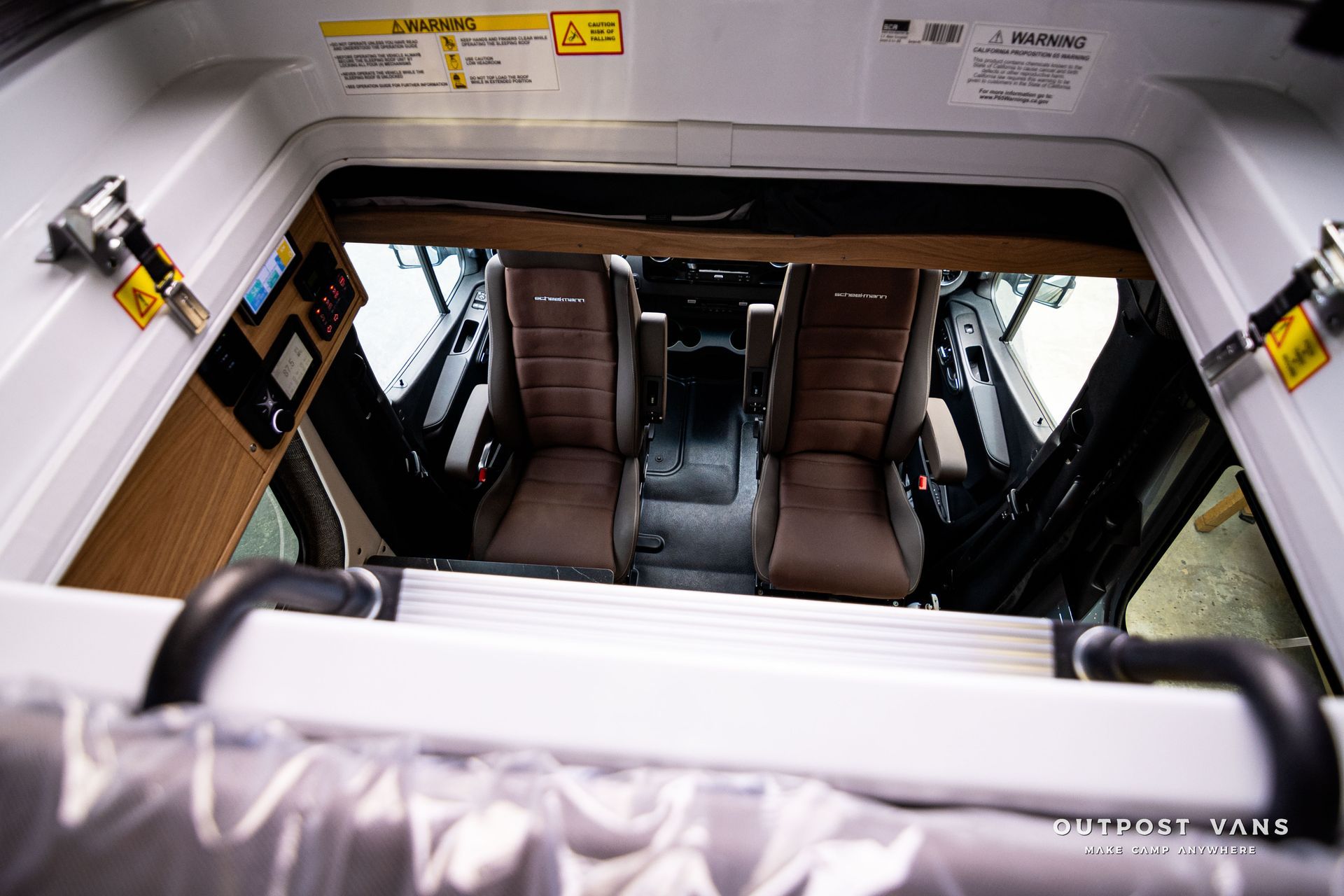 The inside of a bus with a ladder and seats.