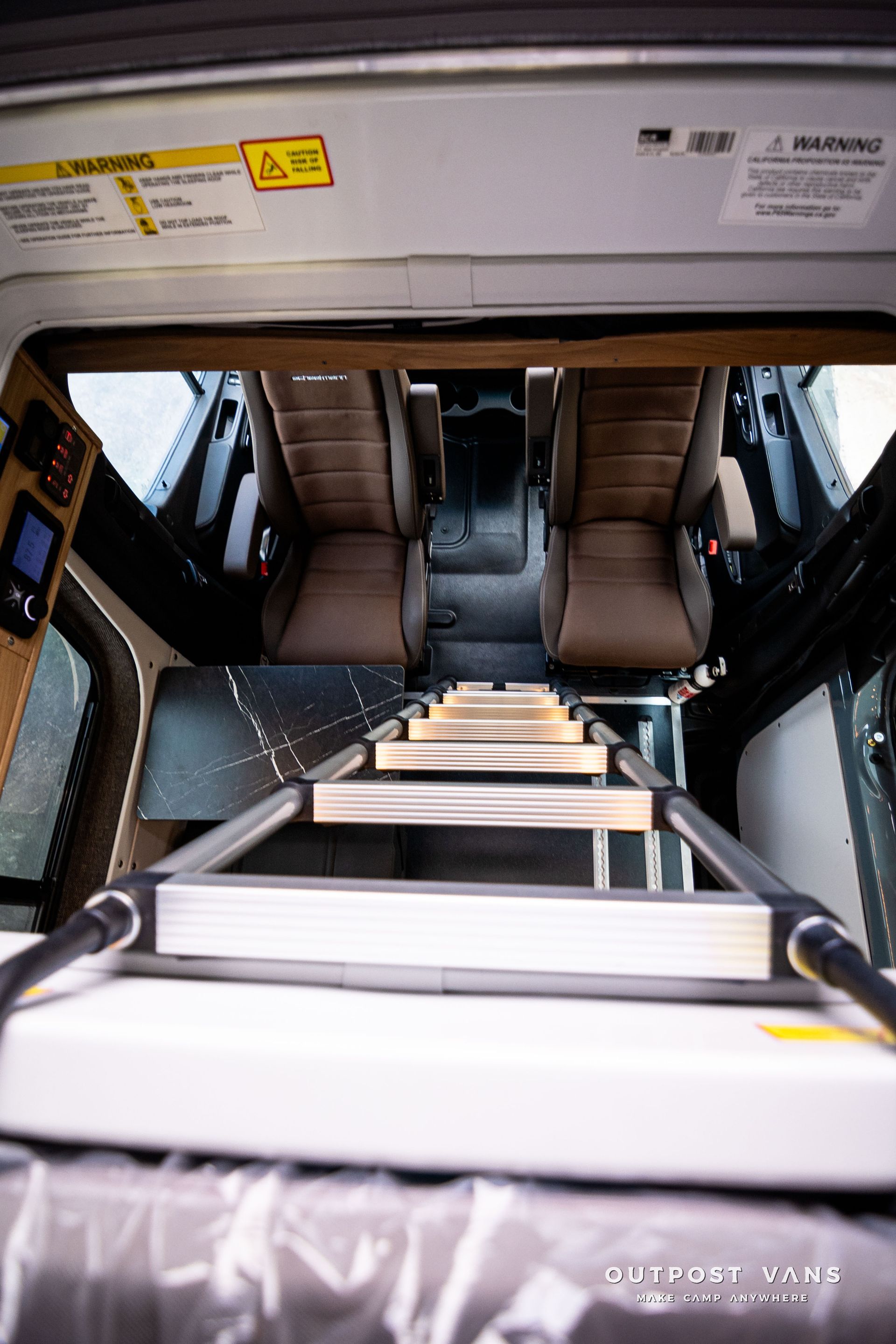 A ladder is going up to the roof of a van.