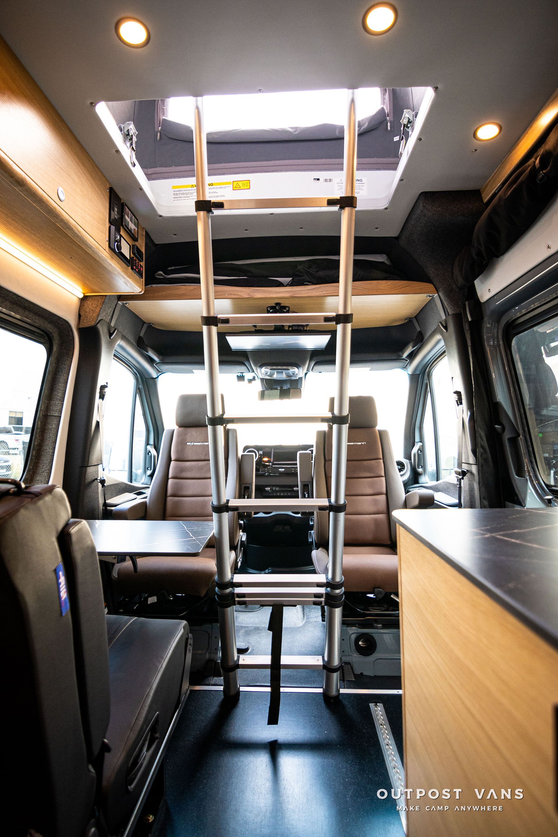 The inside of a van with a ladder and a table.