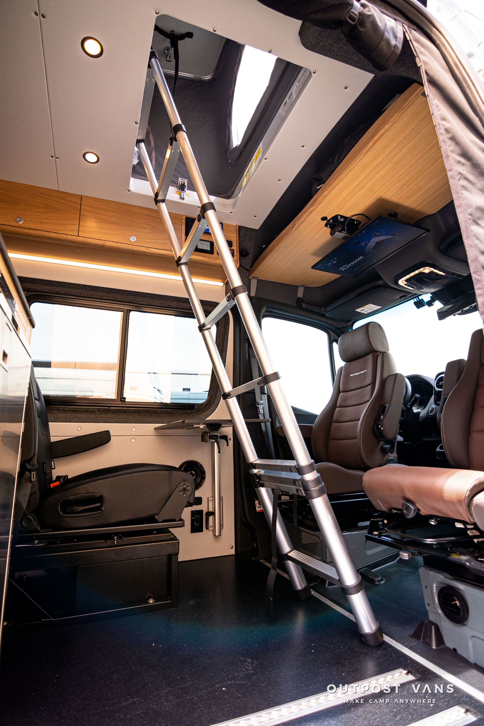 The inside of a van with a ladder leading up to the roof.