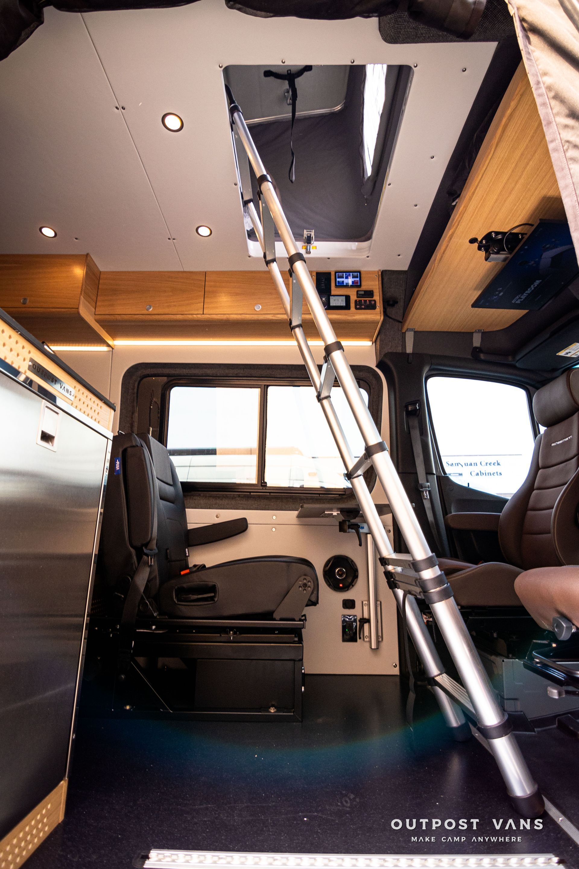 A ladder is hanging from the ceiling of a van.