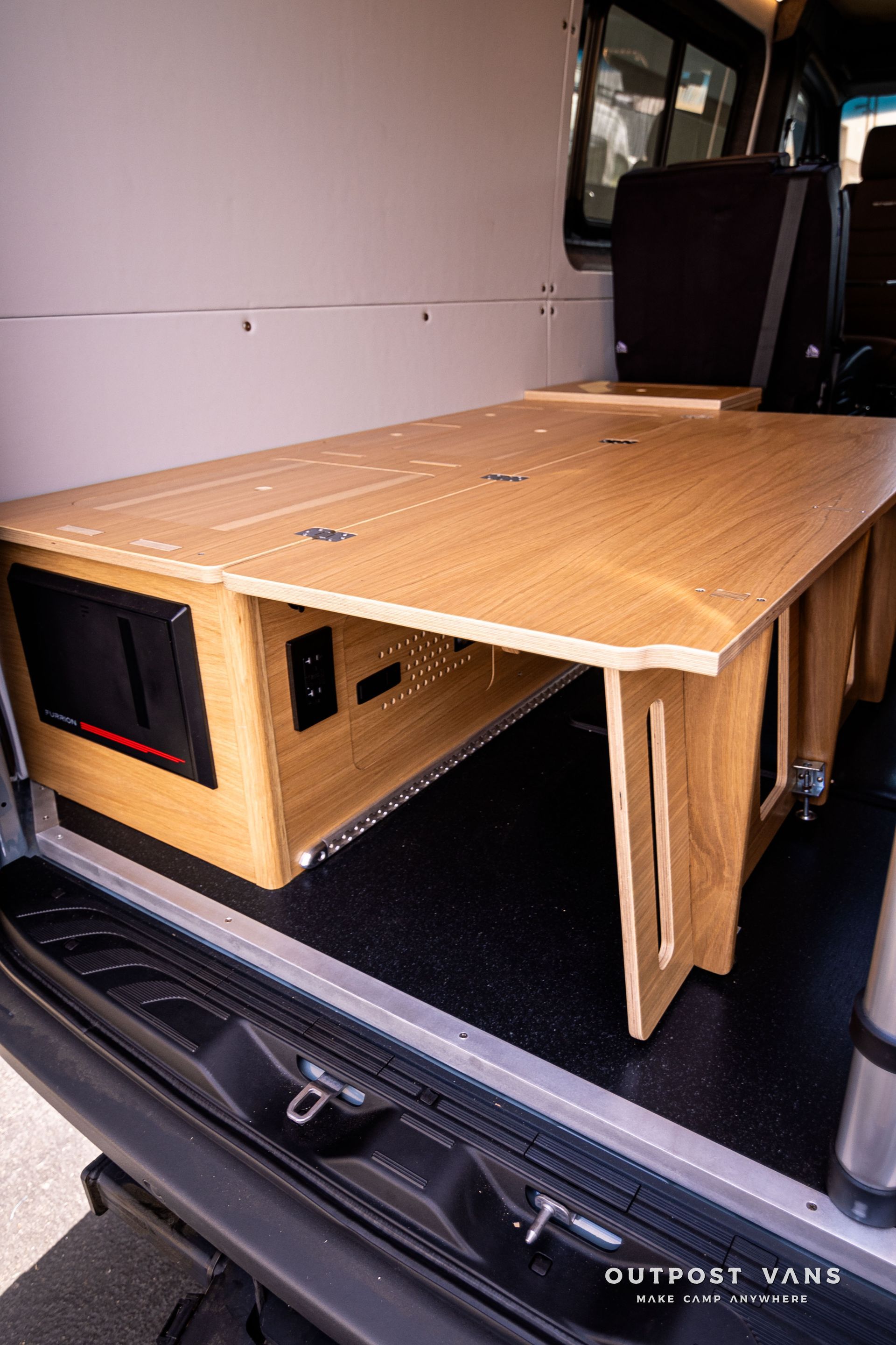 A wooden bed is sitting in the back of a van.