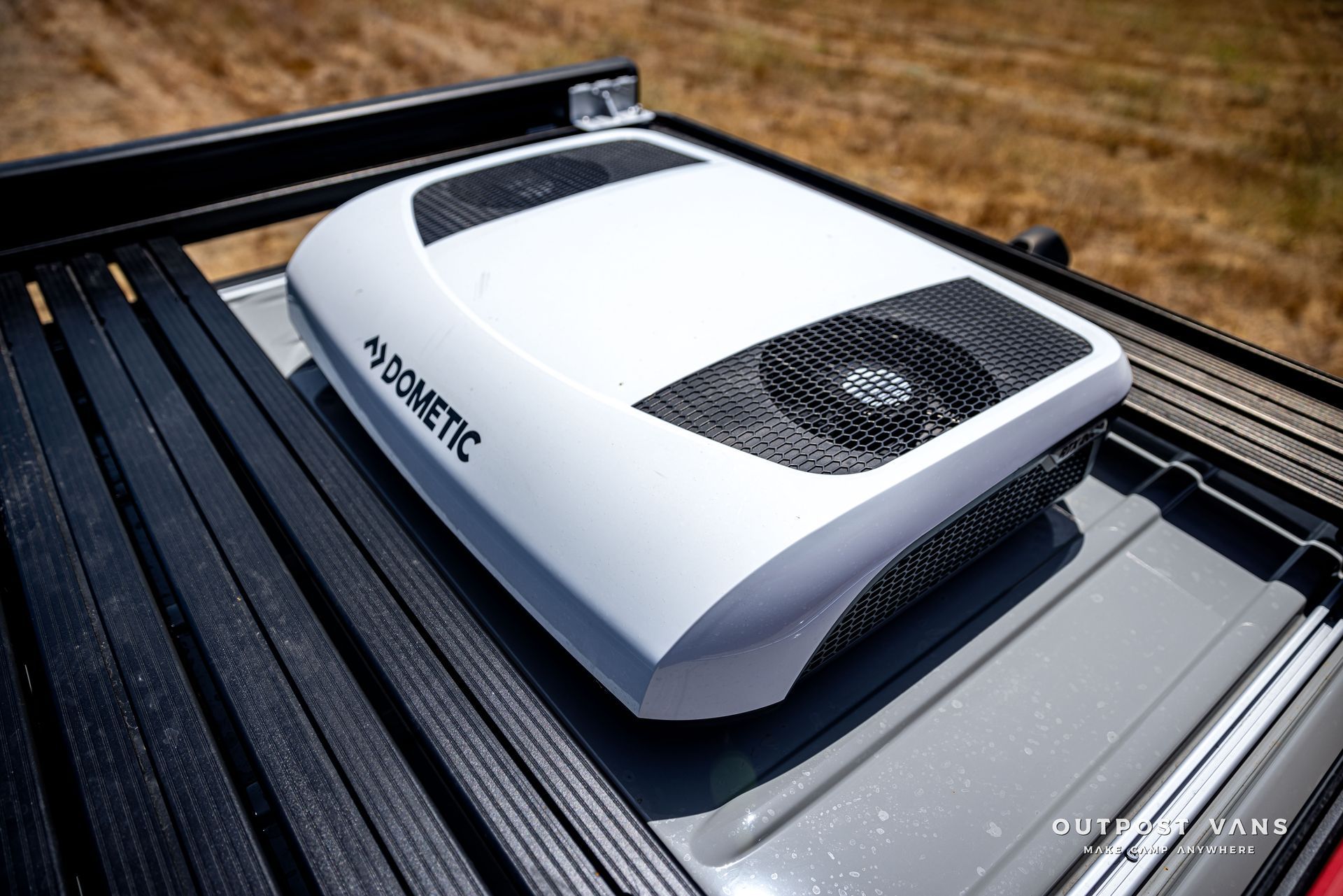 A dometic air conditioner is sitting on top of a truck bed.