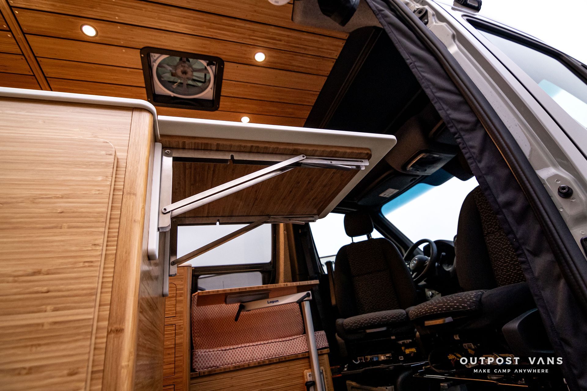 A van with a folding table and a fan on the ceiling.