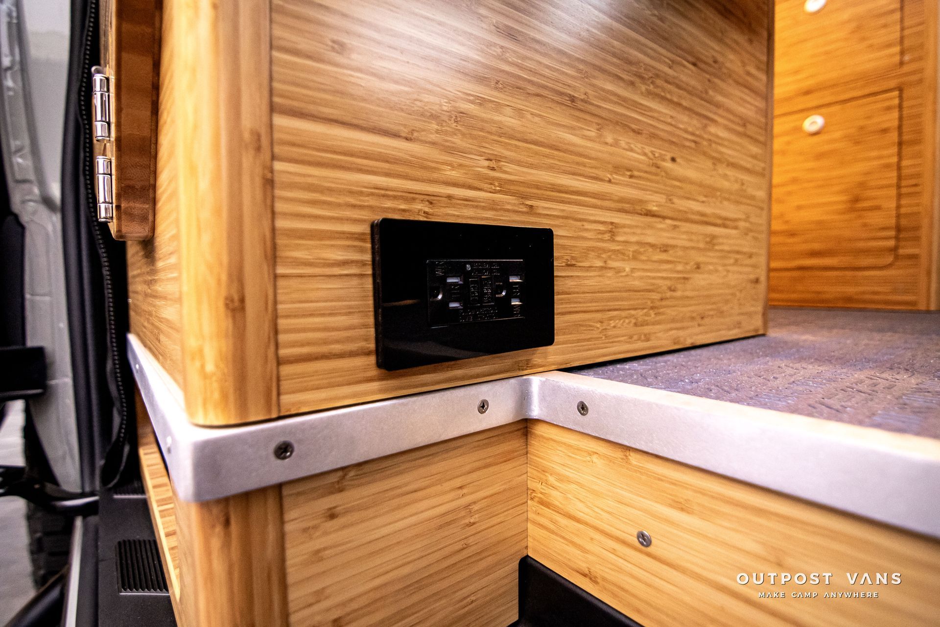 A wooden wall with a black electrical outlet on it.