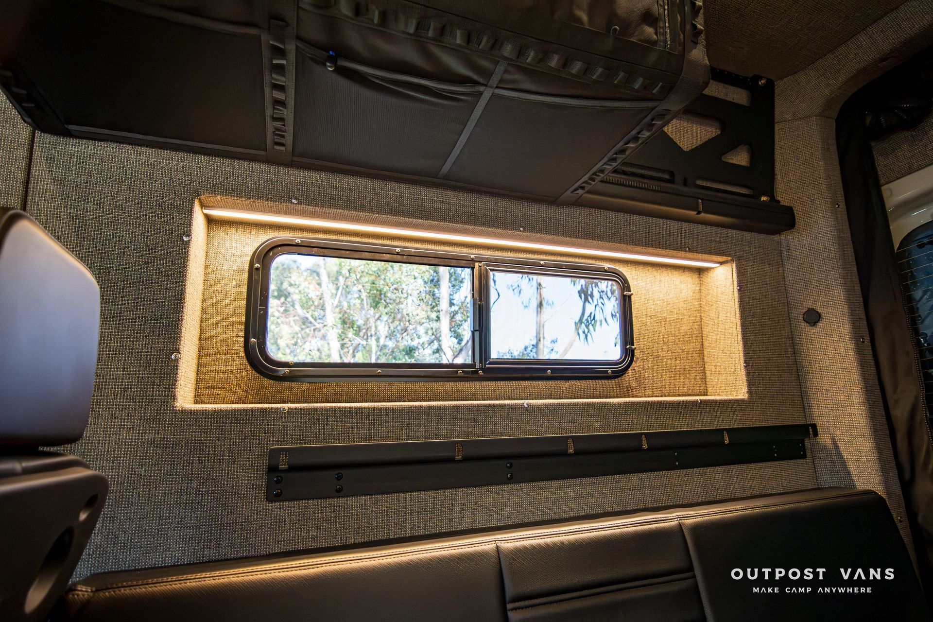 A room with a window and a couch in it.