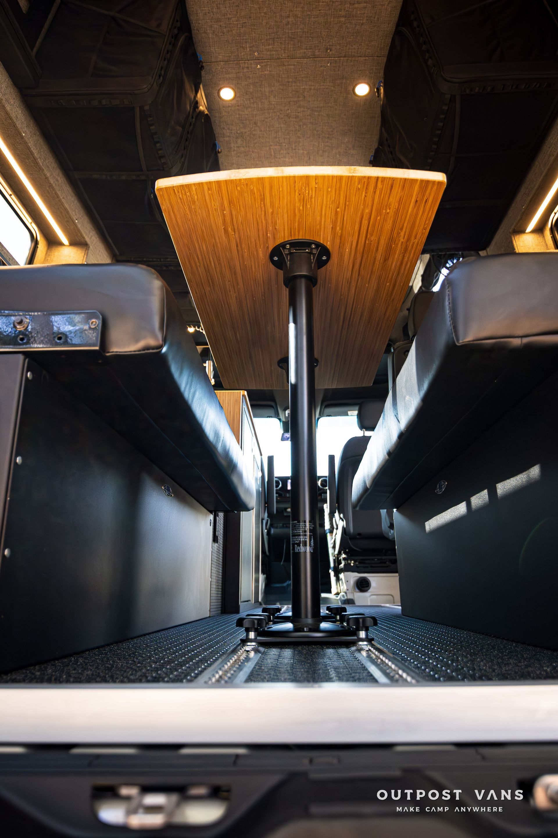A wooden table is sitting in the back of a van.