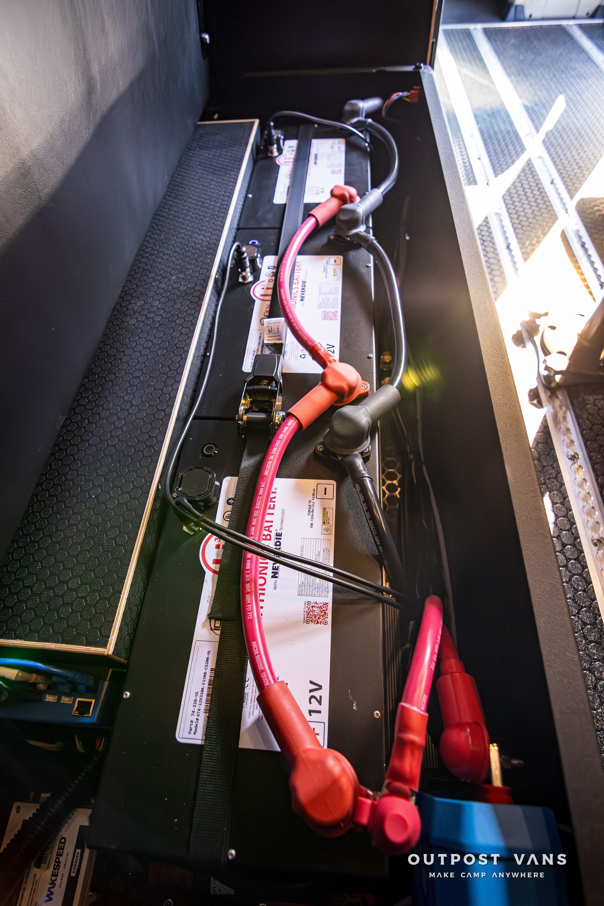 A bunch of wires are connected to a battery in a van.