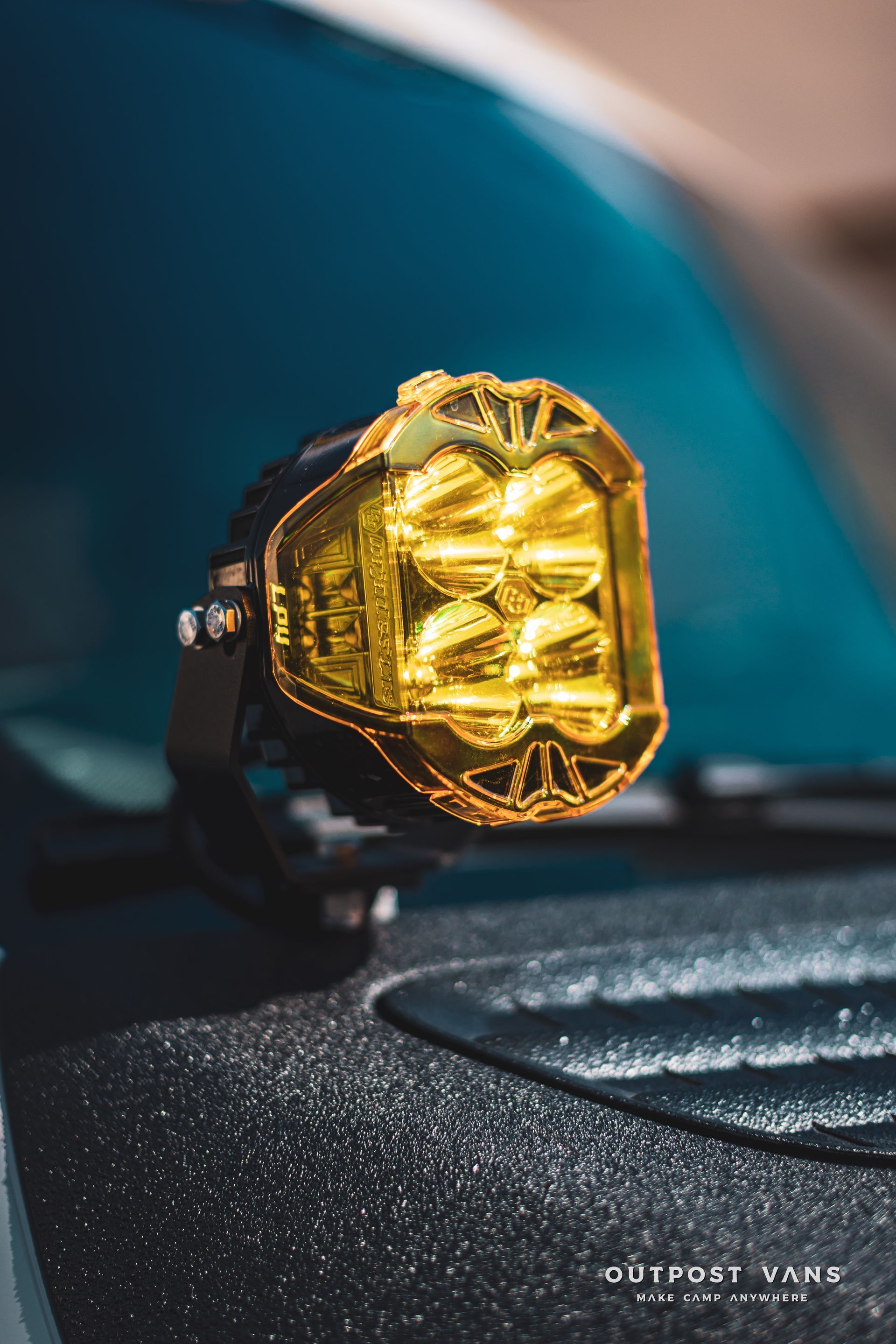 A close up of a yellow light on the hood of a car.