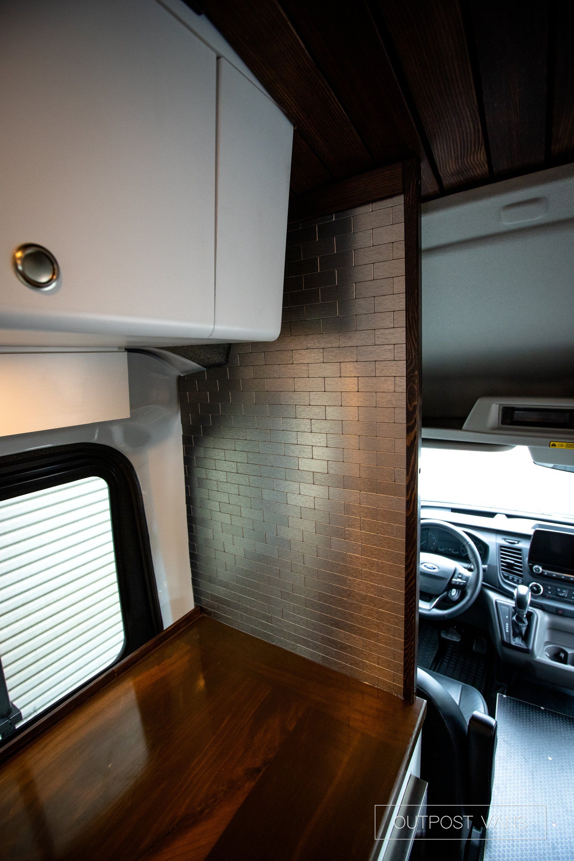 the inside of a van with a wooden table and cabinets .