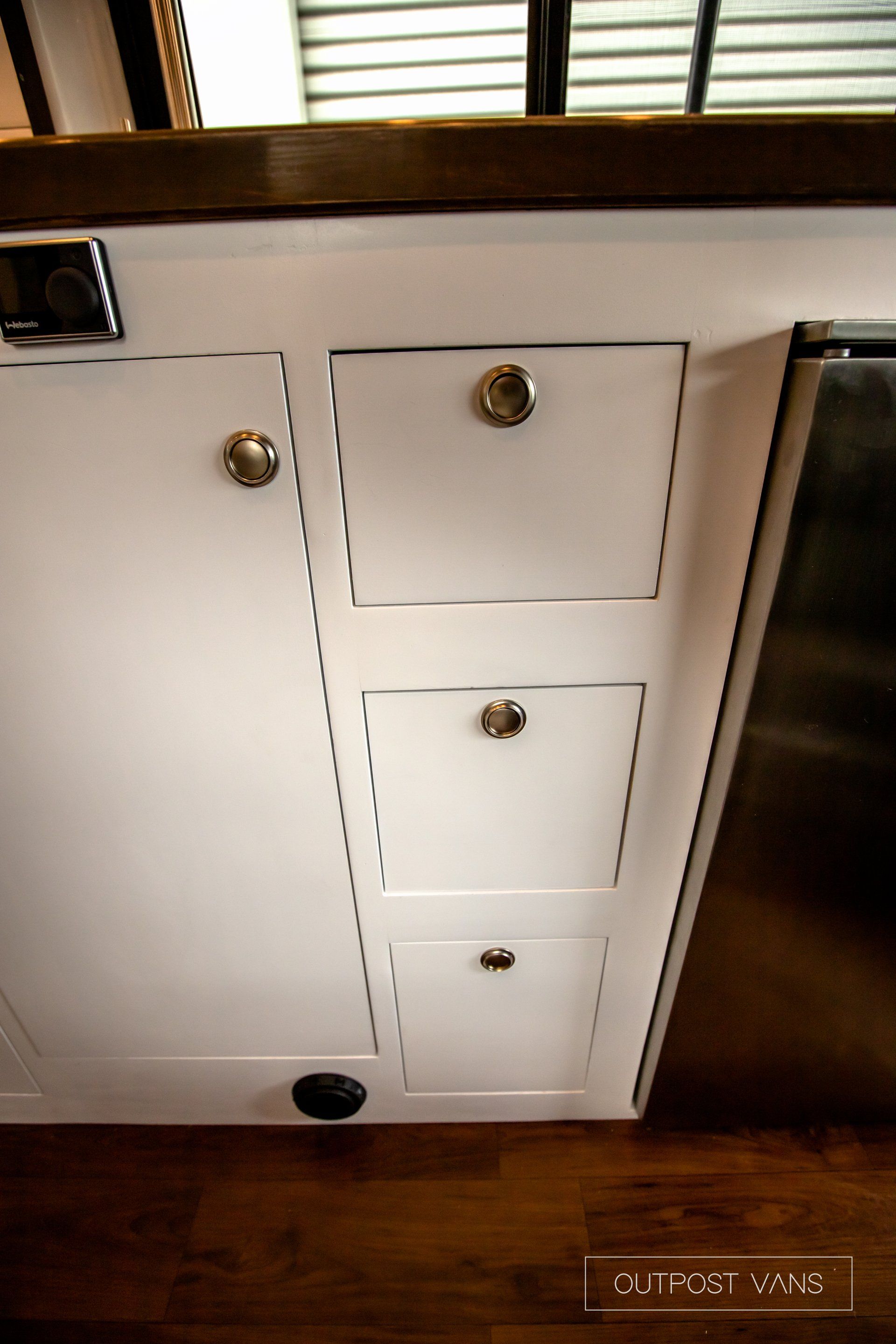 a kitchen with white cabinets and a stainless steel refrigerator .