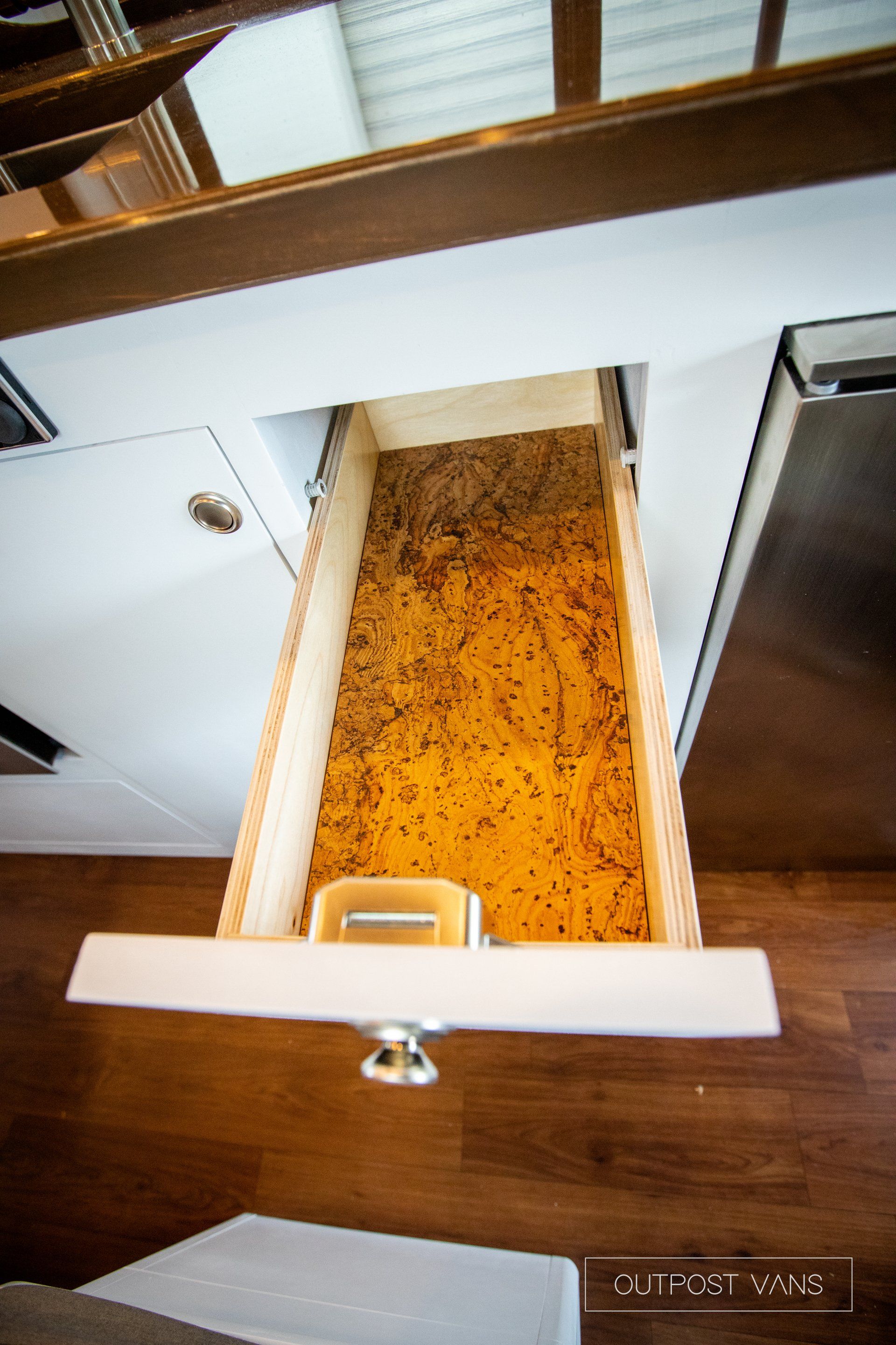 a drawer in a kitchen with a container of spice in it .