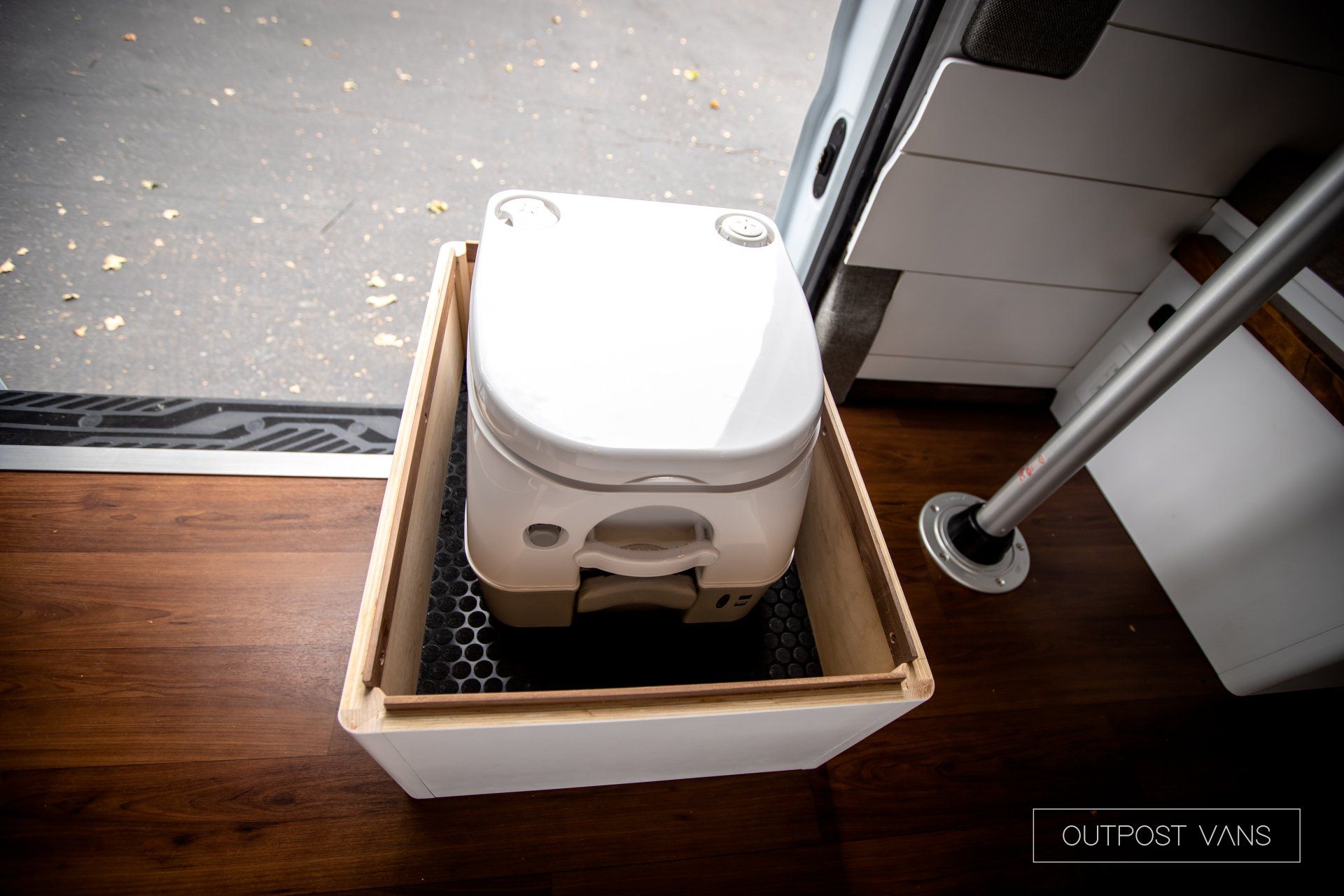 a white toilet is sitting in a box on a wooden floor .