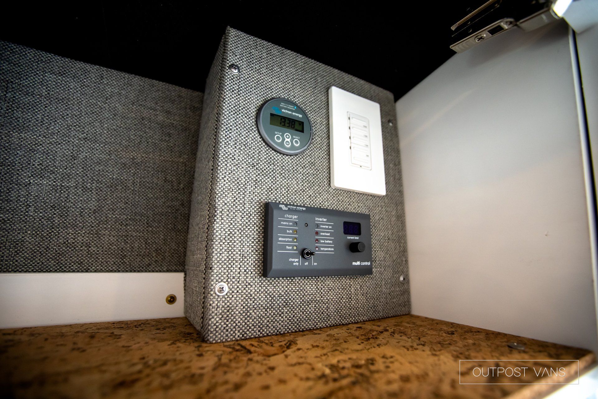 a corner of a room with a clock and a switch on the wall .