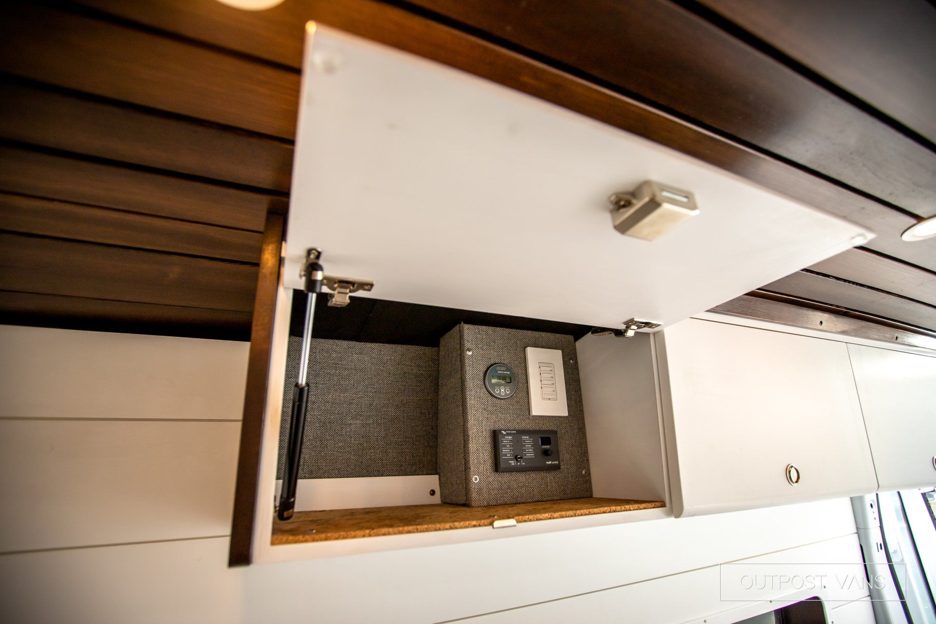 a cabinet with the door open and a box inside of it .