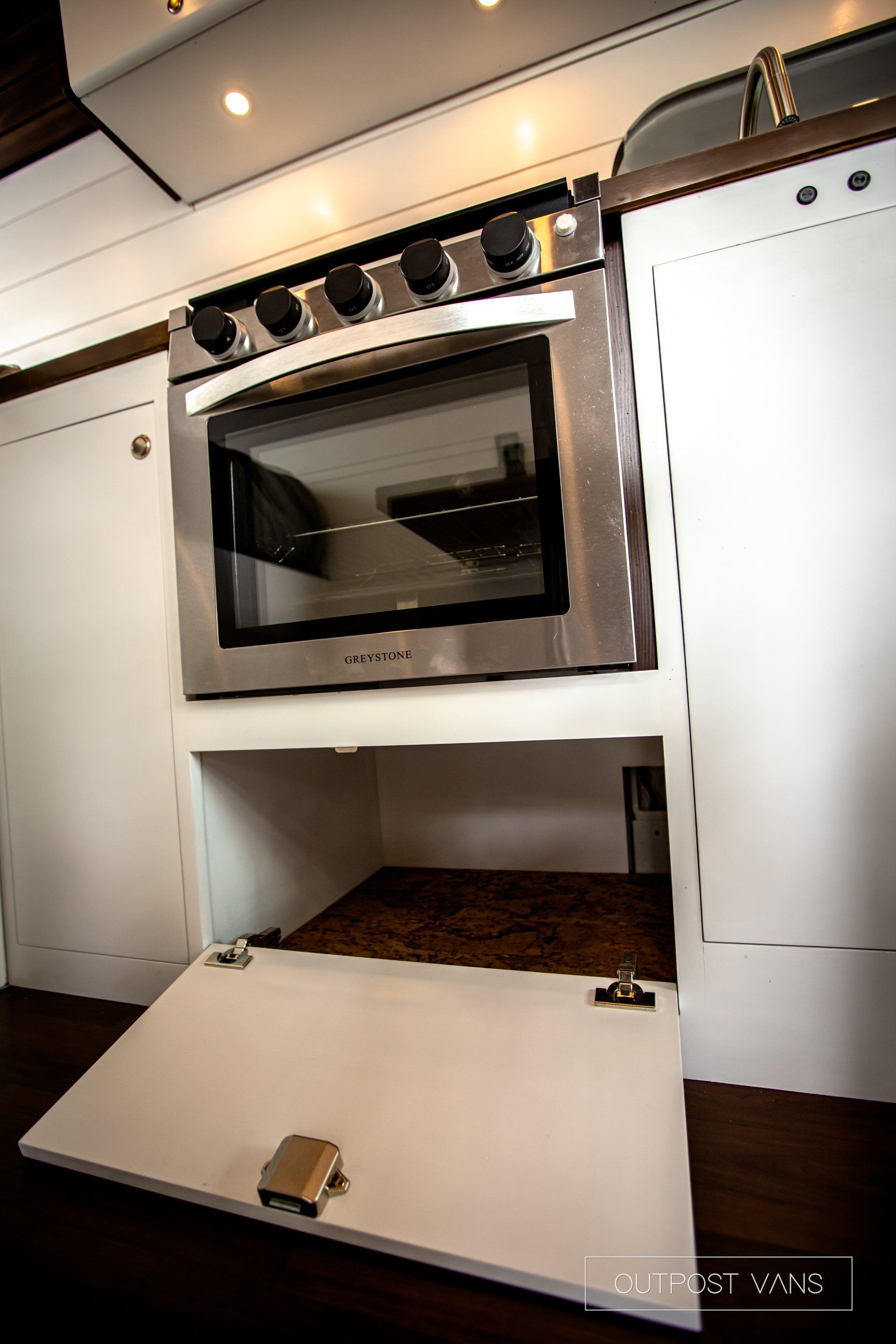 a kitchen with a stove and oven with the door open .