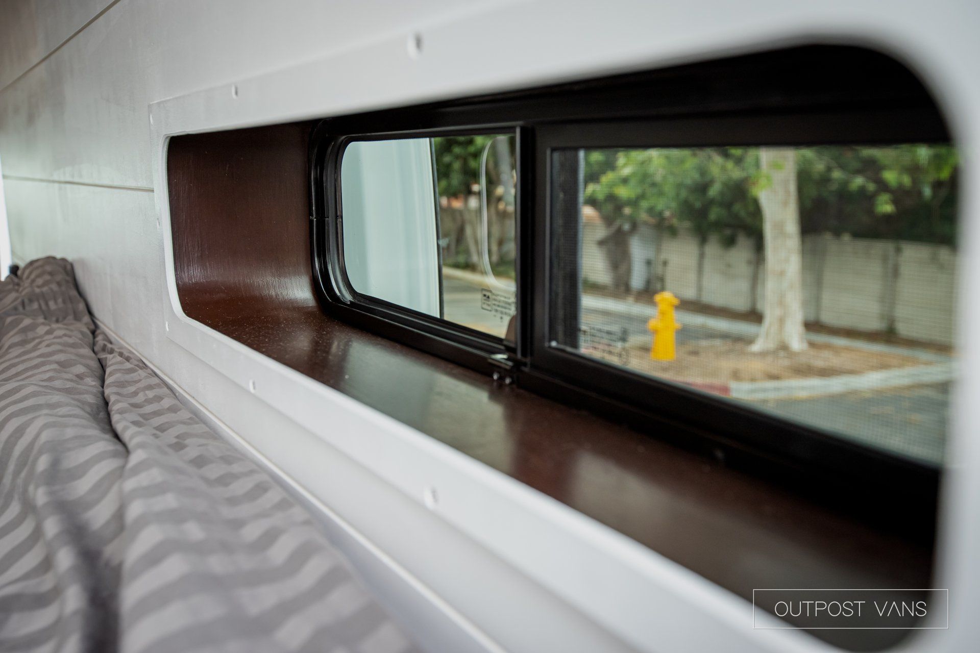a close up of a window in a van with a fire hydrant in the background .