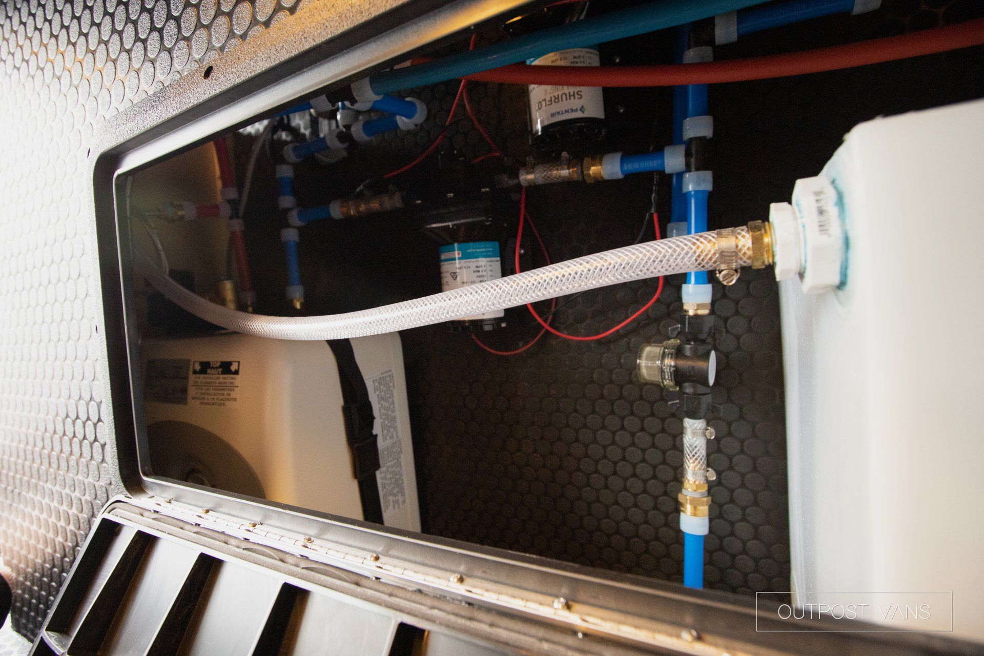 a hose is connected to a water tank in a cabinet .
