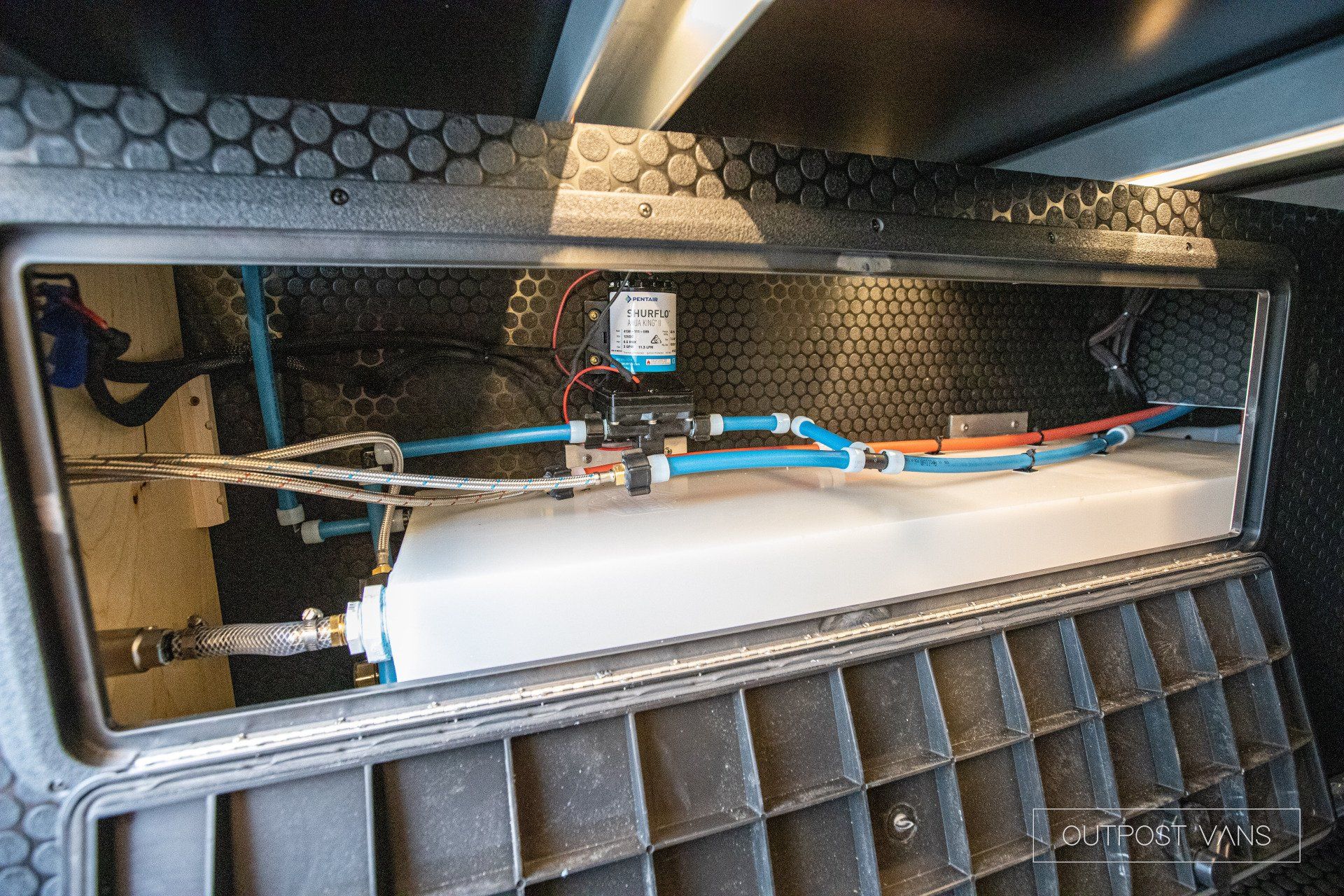 a large white tank is sitting inside of a metal box .