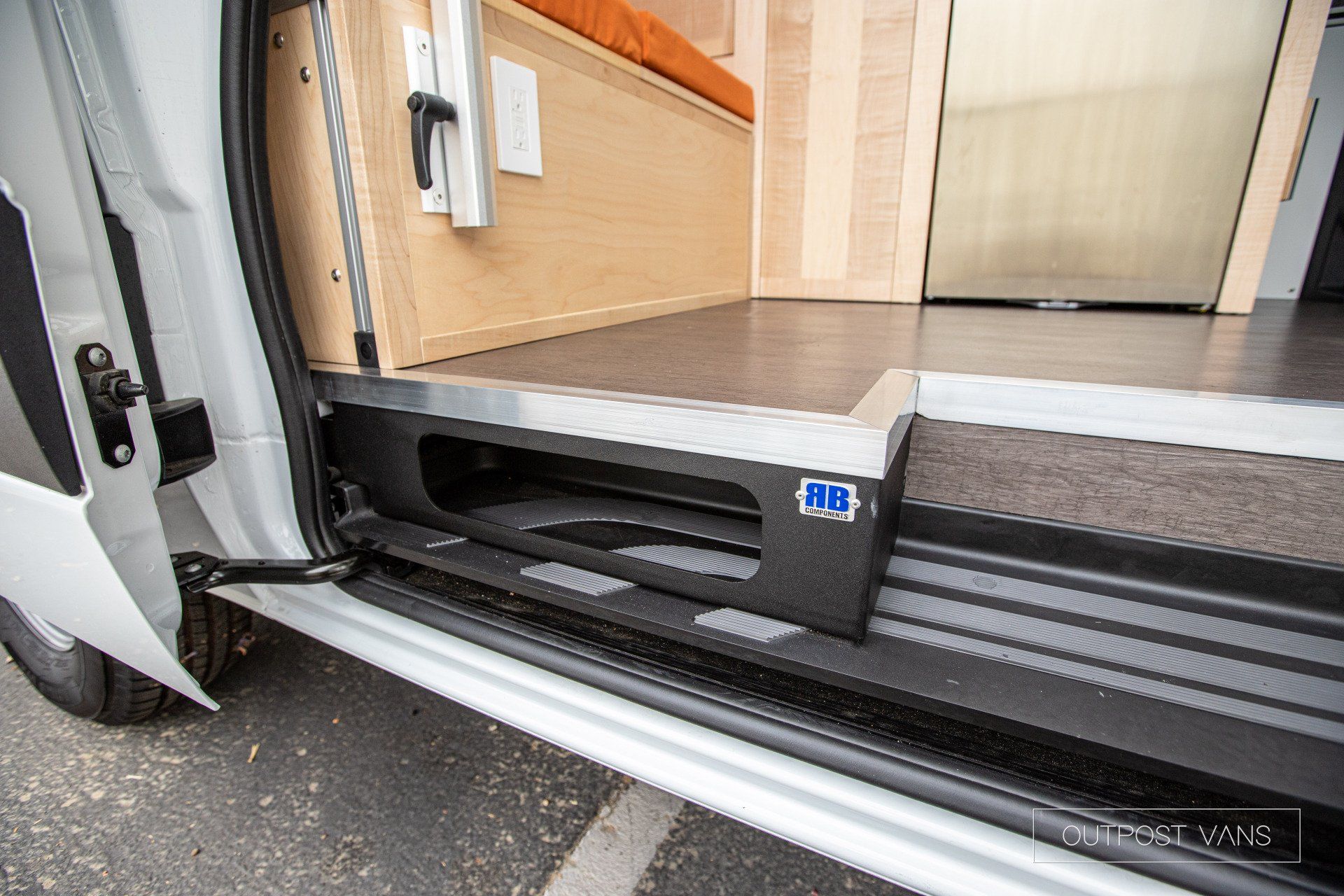 a white van with the door open is parked in a parking lot .