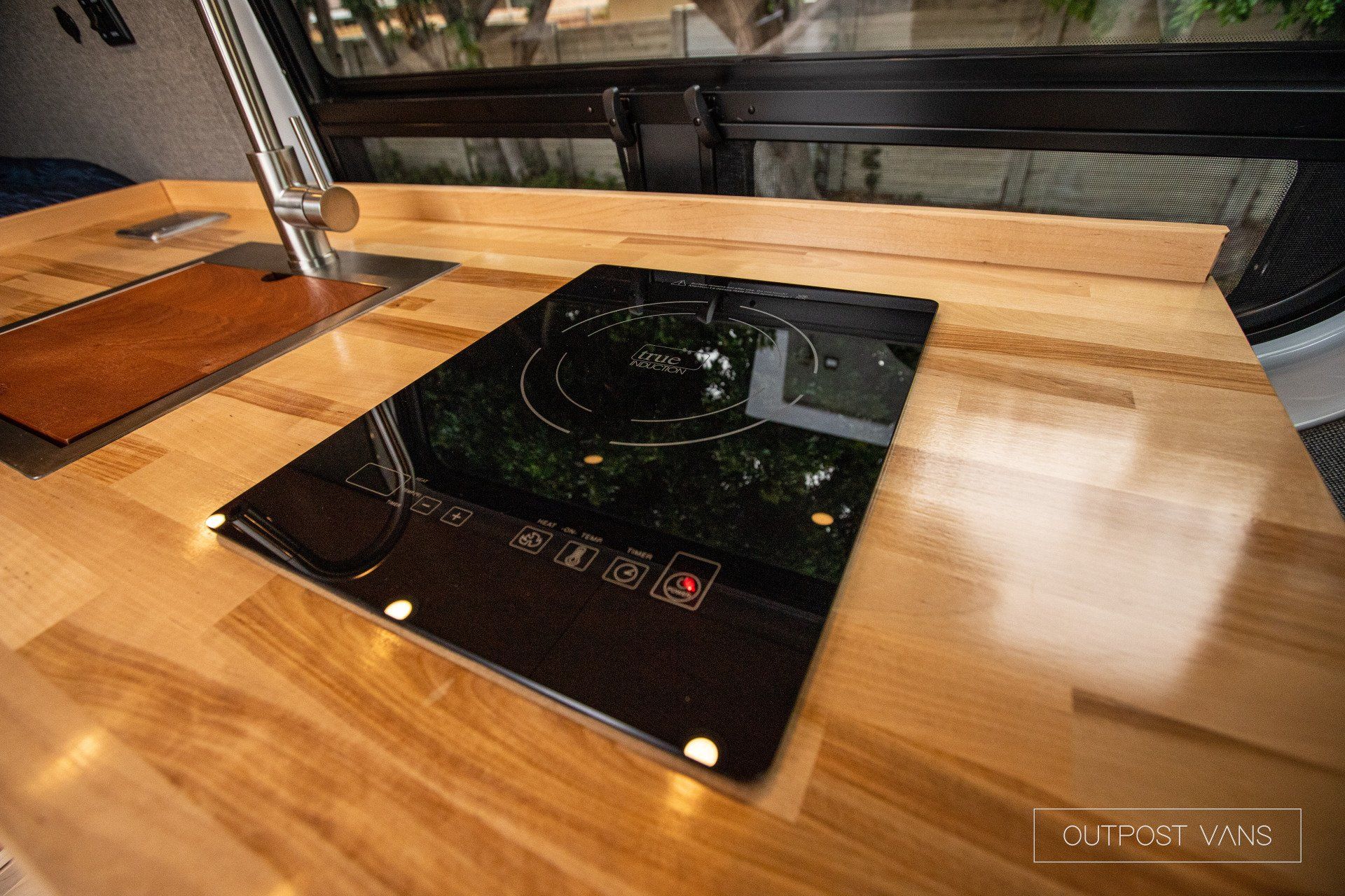 a black stove top oven is sitting on top of a wooden counter .