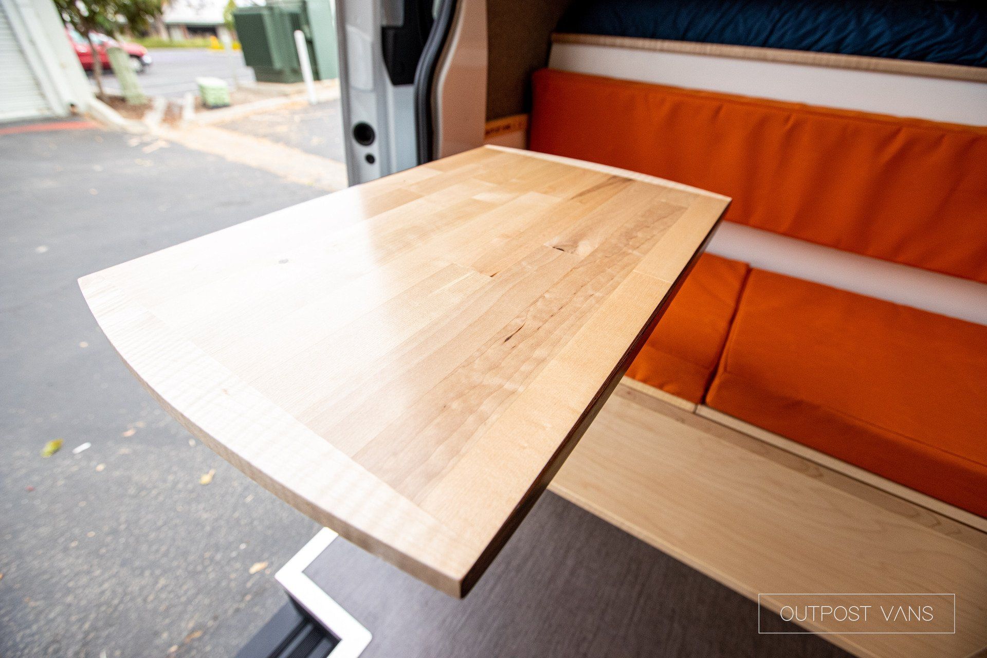 a wooden table is sitting in the back of a van .