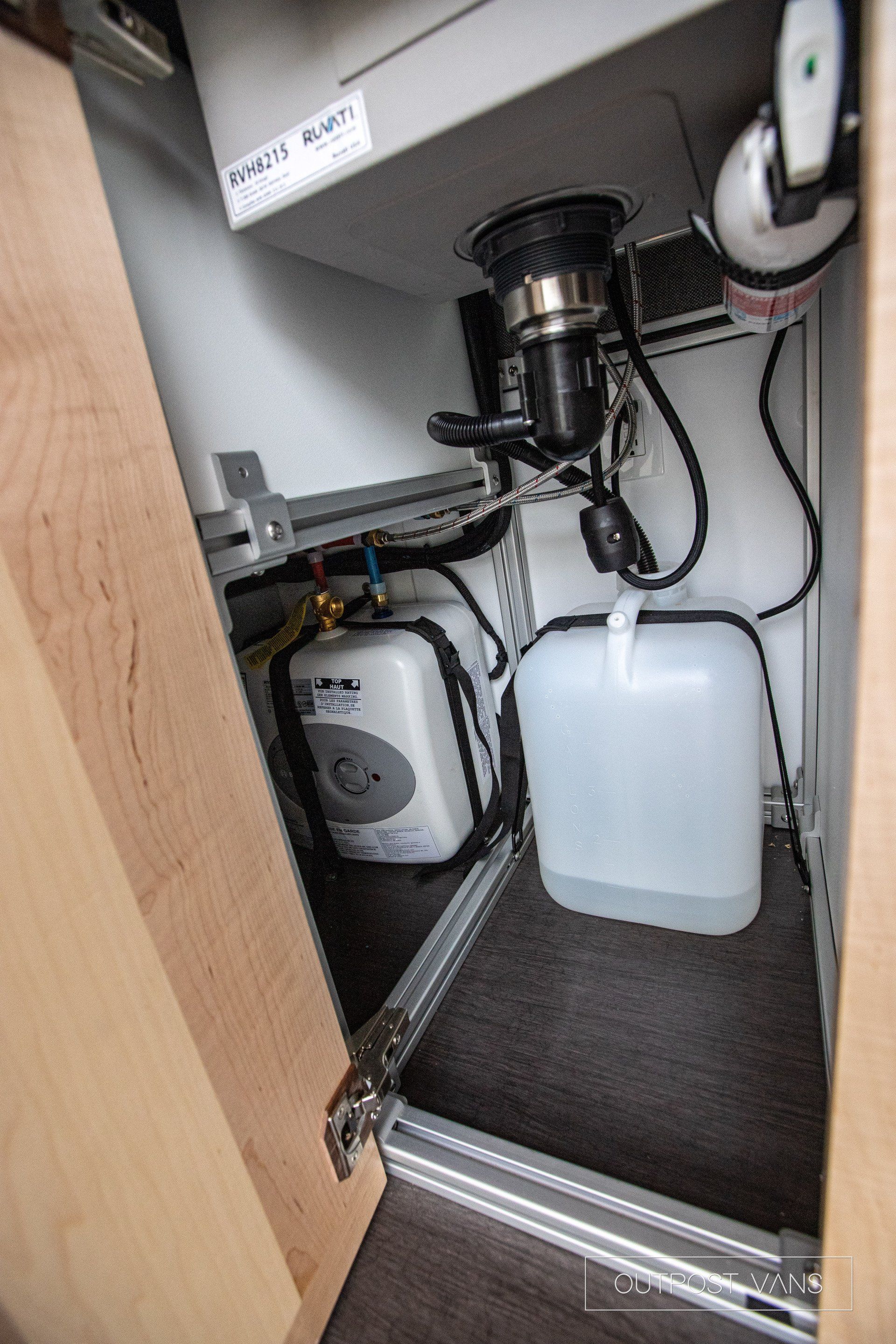 a kitchen sink with a bottle of water underneath it .