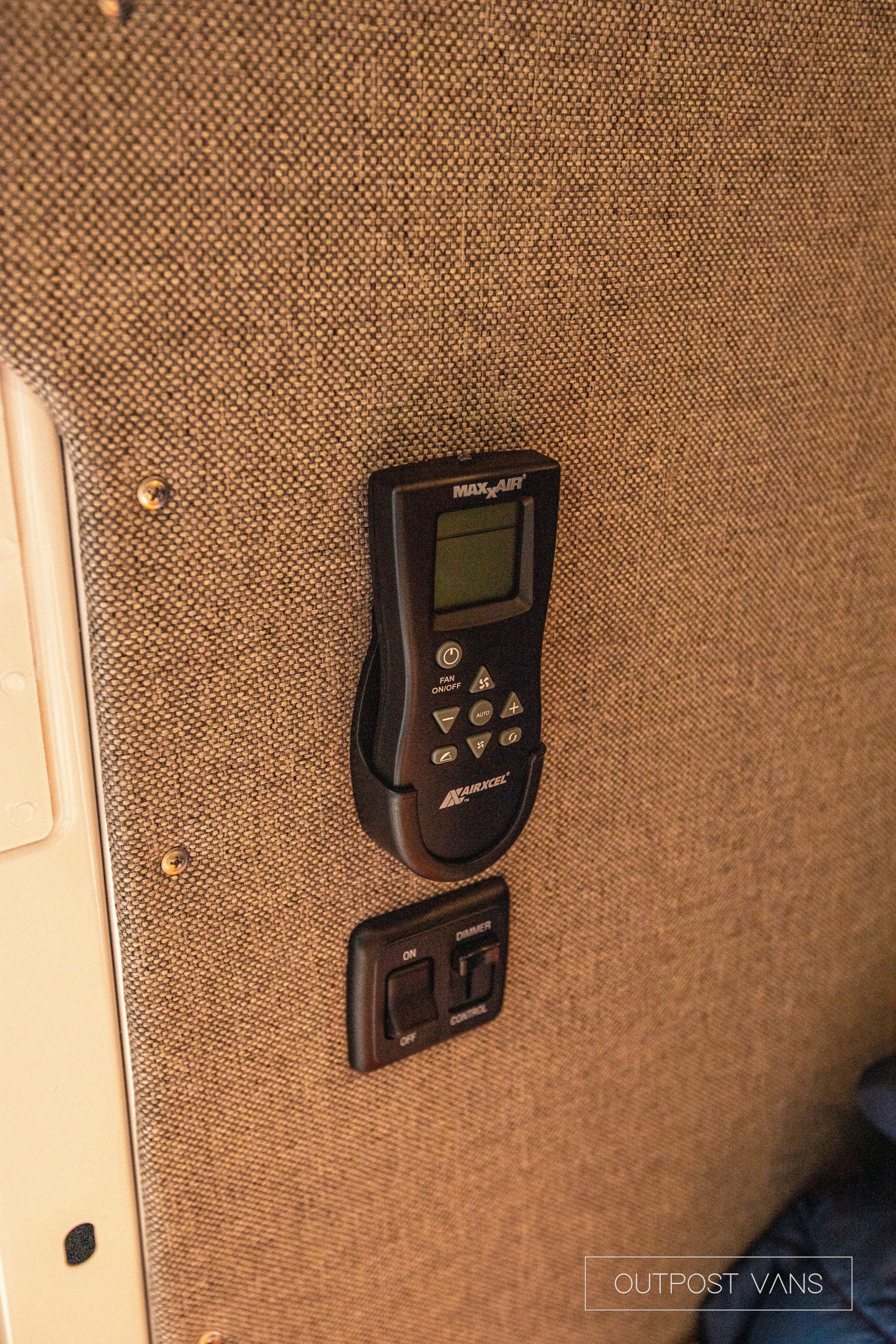 a remote control is hanging on a wall next to a switch .