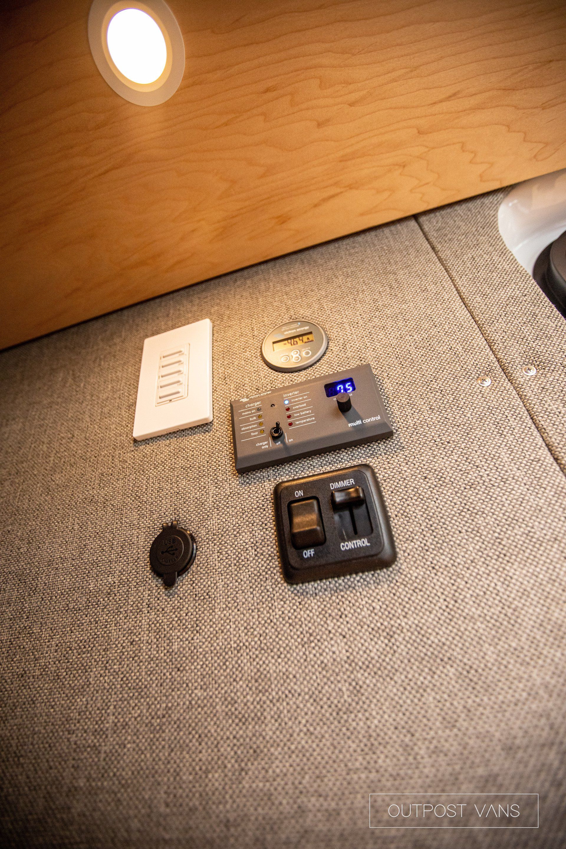 a remote control is sitting on the floor next to a light switch .