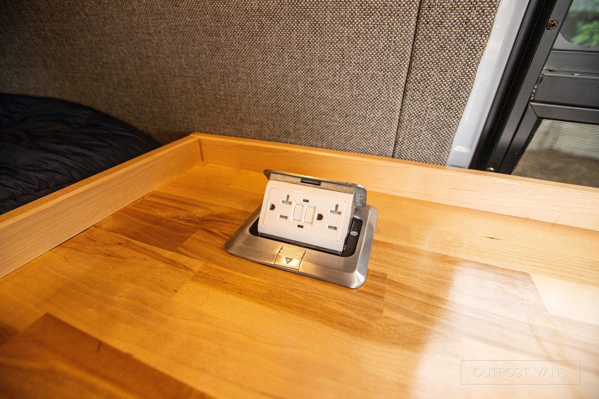 a wooden table with a electrical outlet on it .
