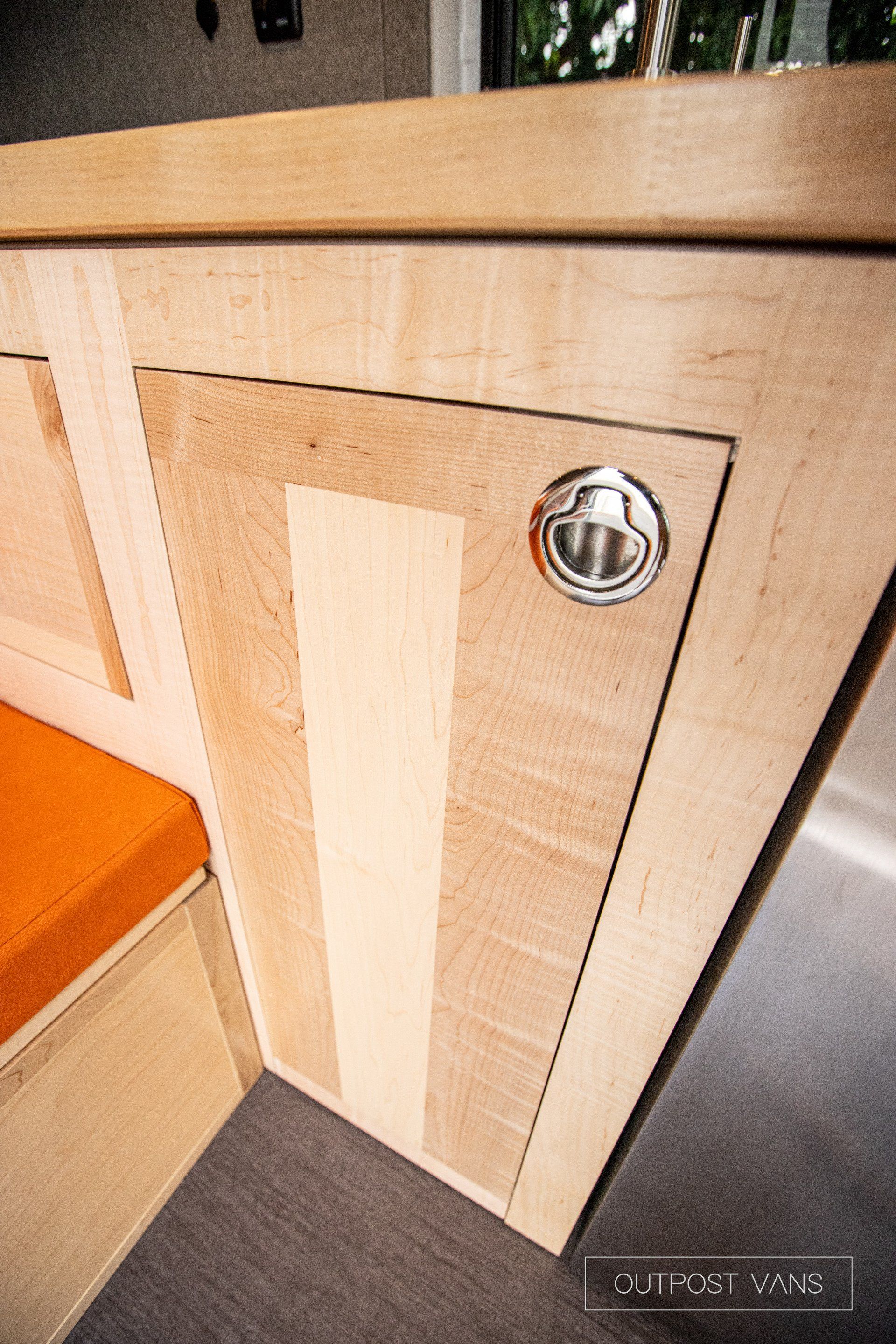 a close up of a wooden cabinet with a metal handle