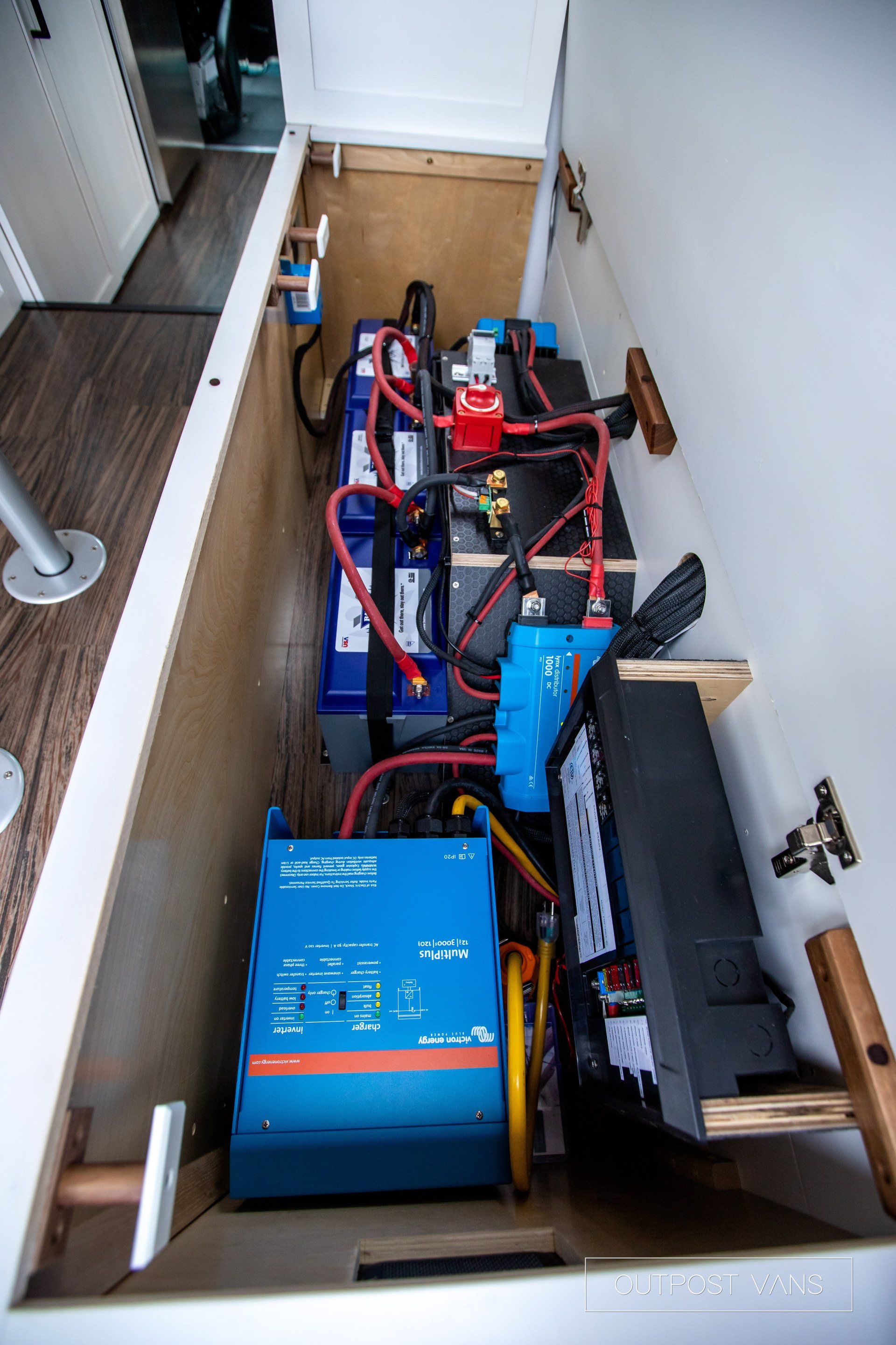 A bunch of batteries are sitting inside of a cabinet.