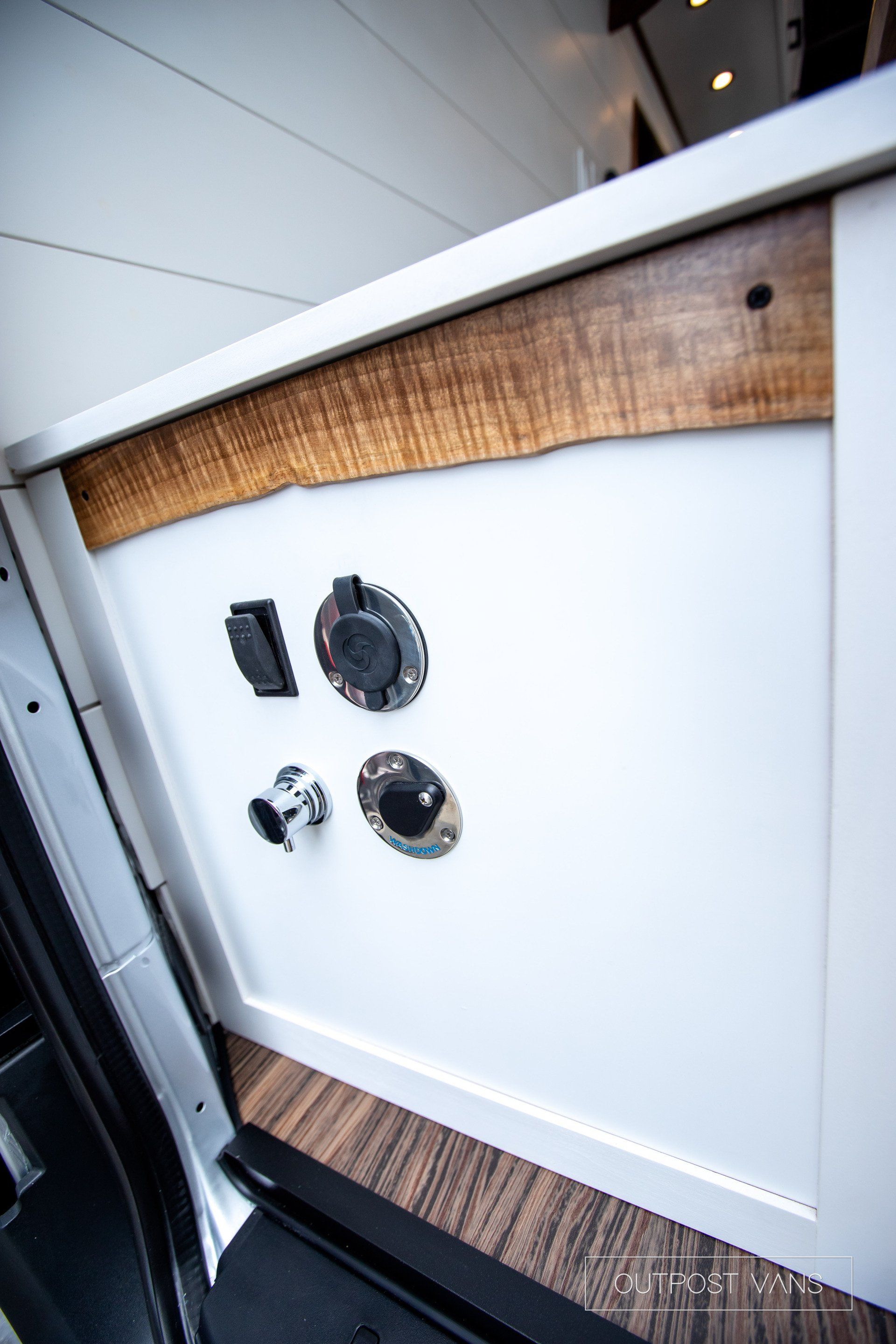 A close up of a white cabinet with a wooden trim.