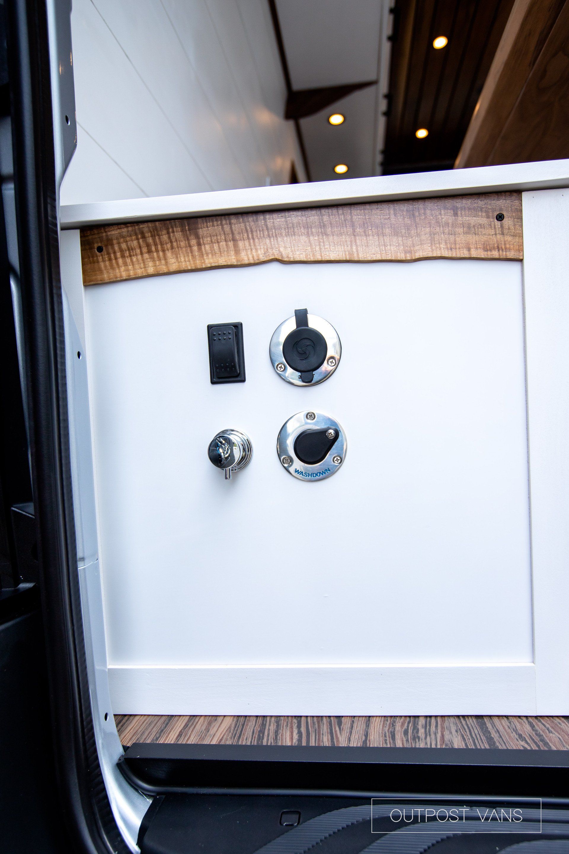 A white cabinet with two outlets on the side of it.