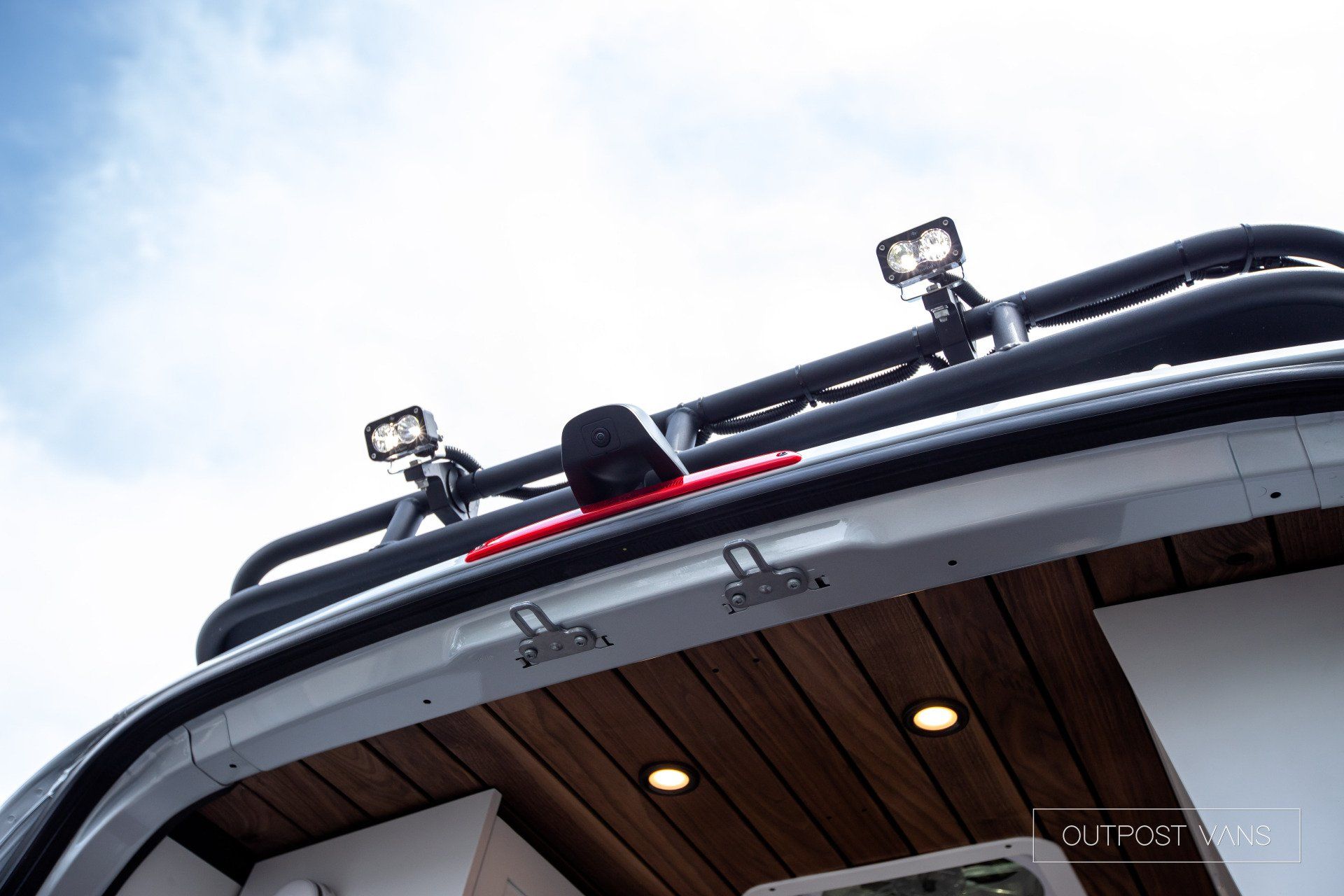 The back of a van with a roof rack and lights on it.