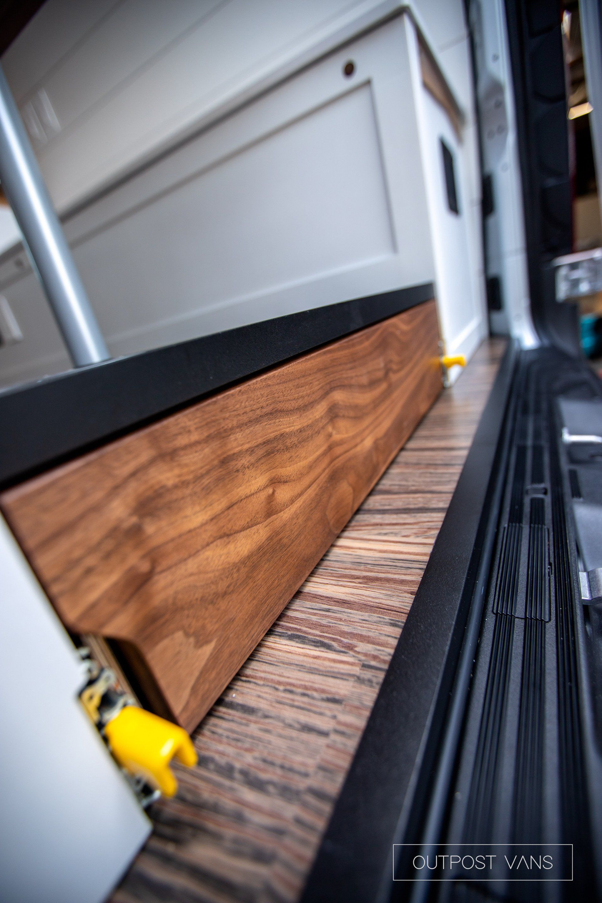 A close up of a wooden floor in a camper van.