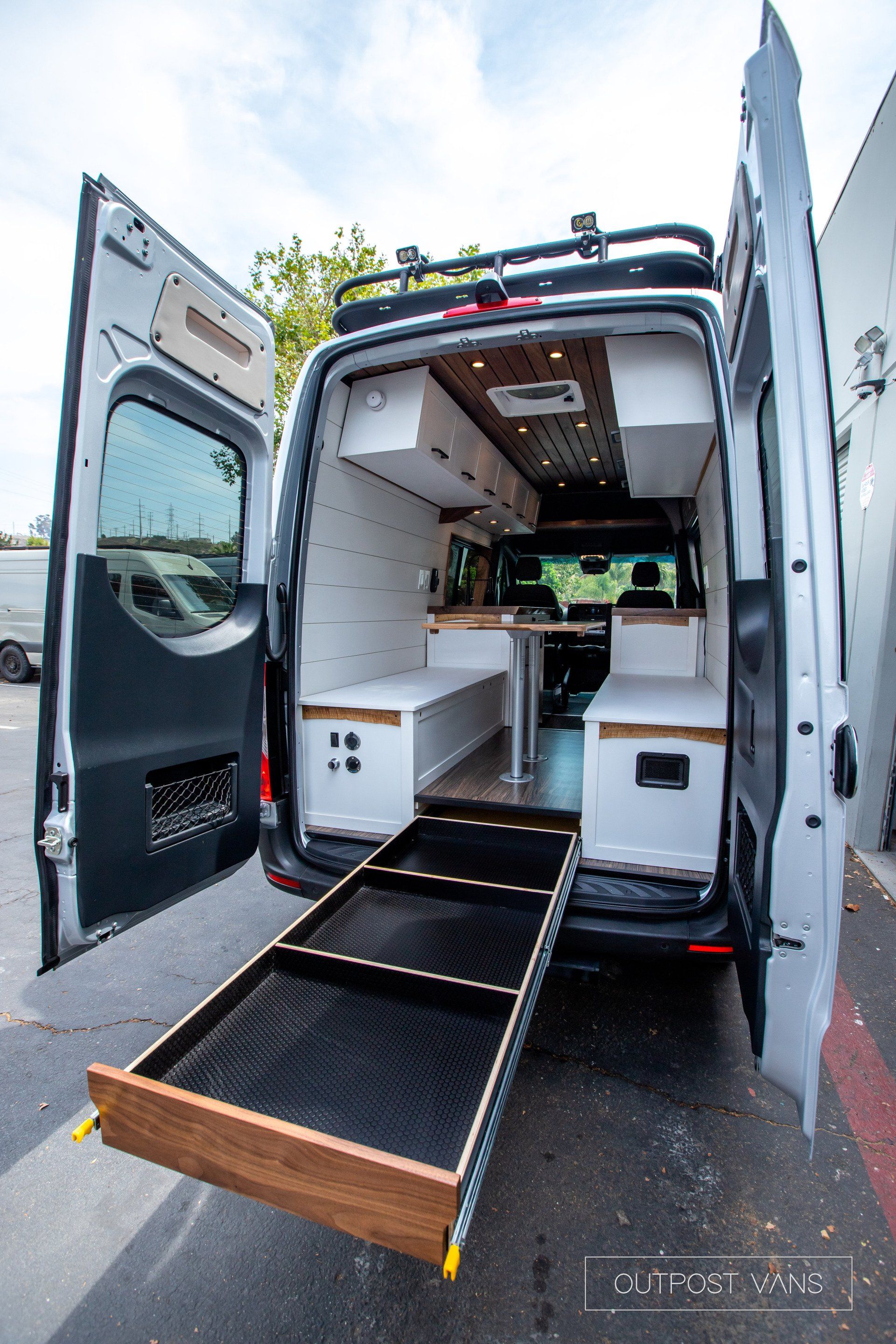 The back of a van with the door open and a drawer in the back.