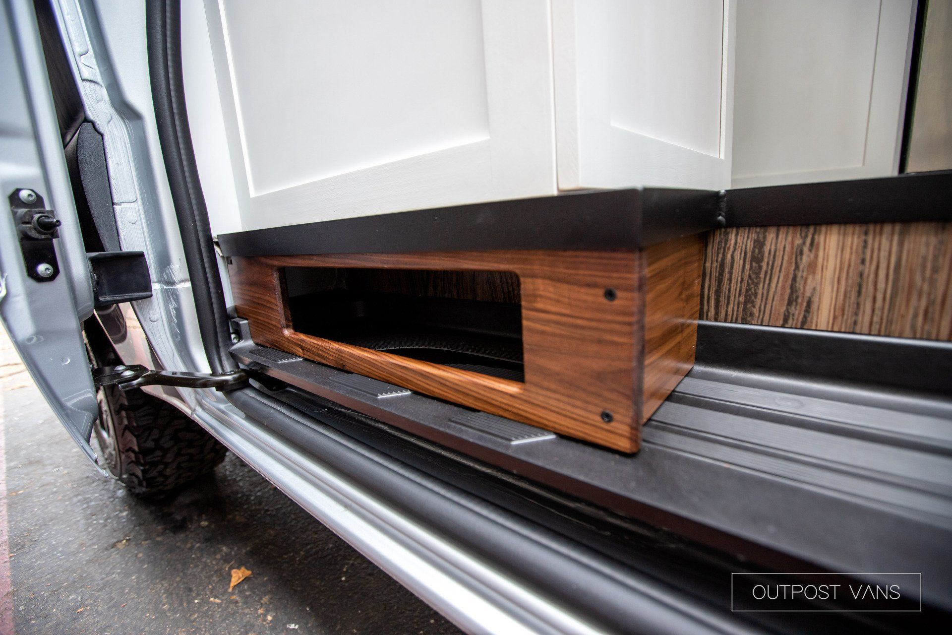 The door of a van has a wooden shelf in it.