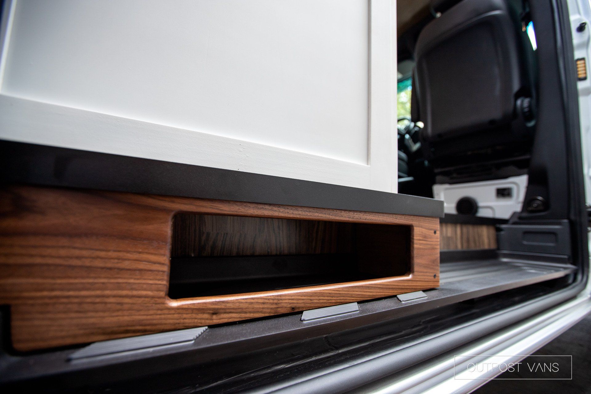 A close up of a wooden box in the door of a van.