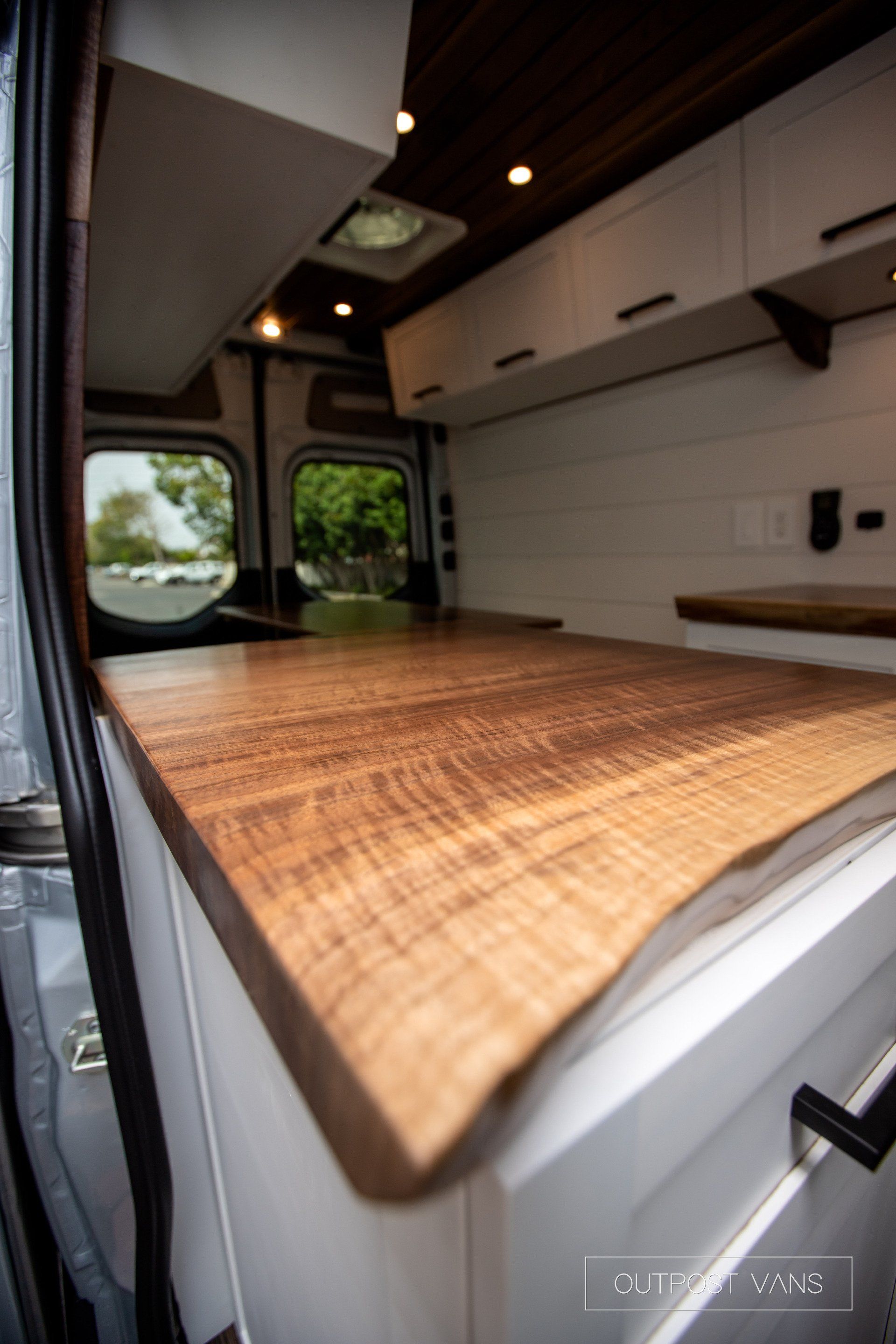A close up of a wooden counter top in a van.