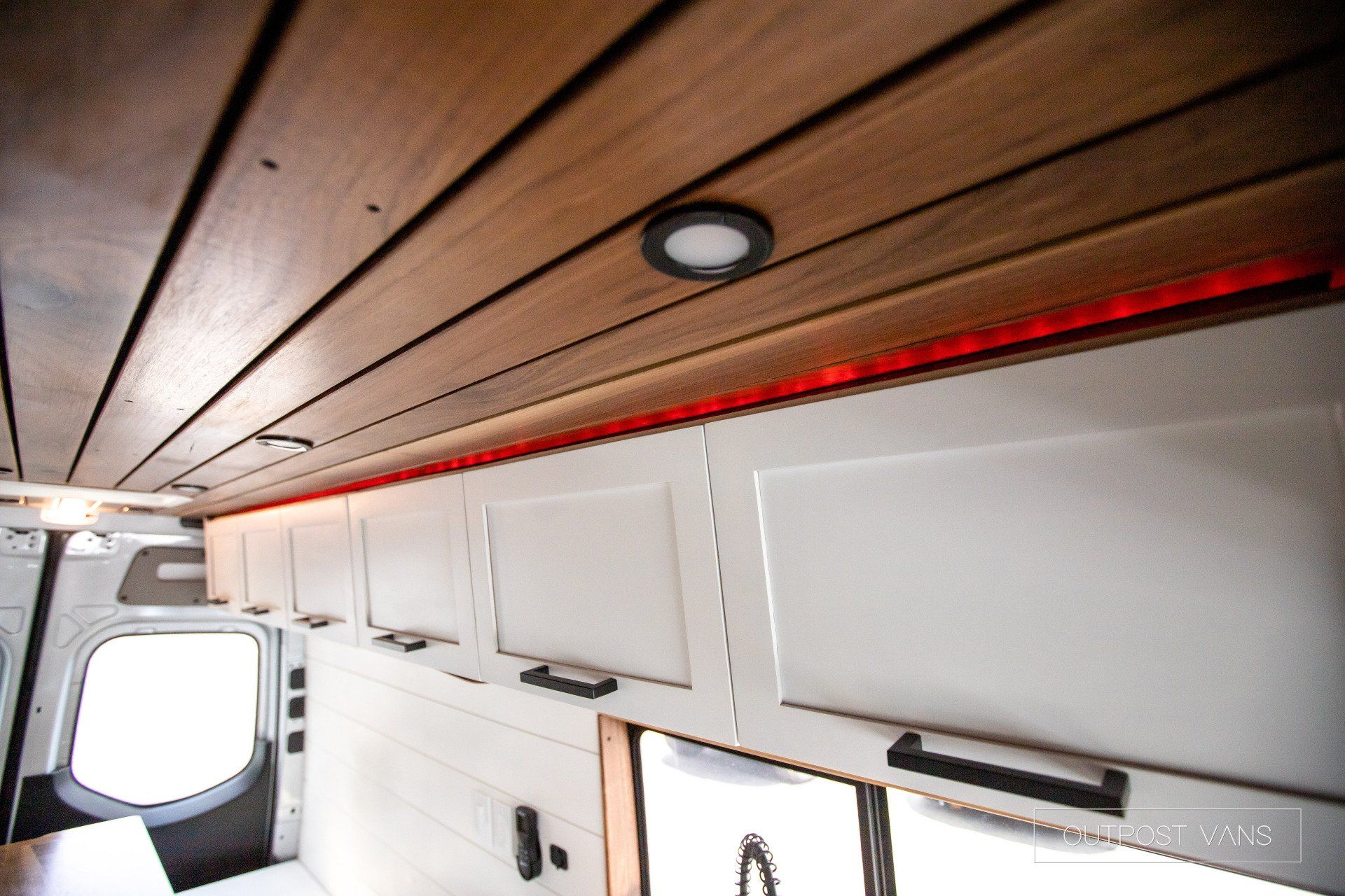 A van with a wooden ceiling and white cabinets
