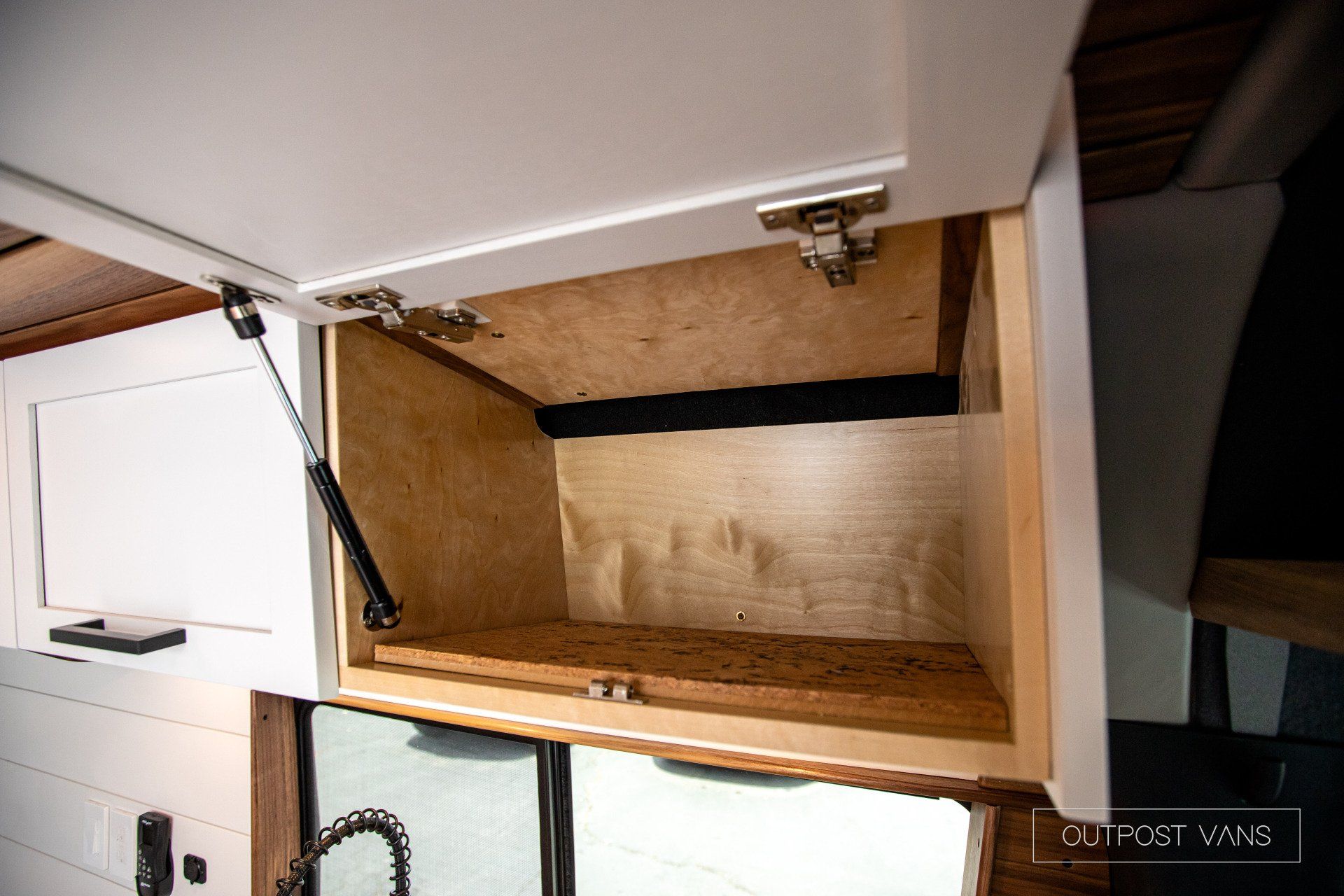 The inside of a cabinet in a kitchen with the door open.