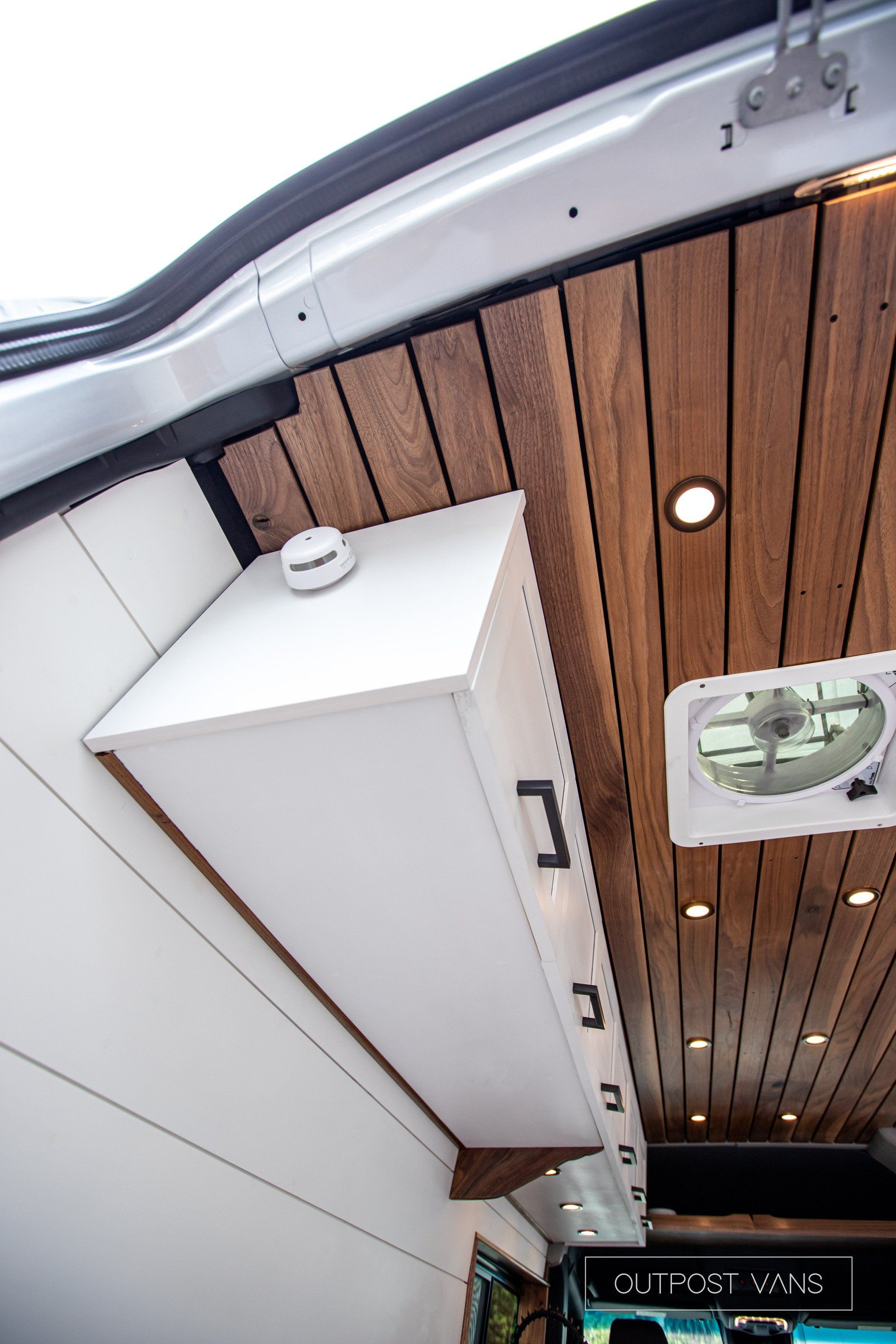 A white van with a wooden ceiling and a fan