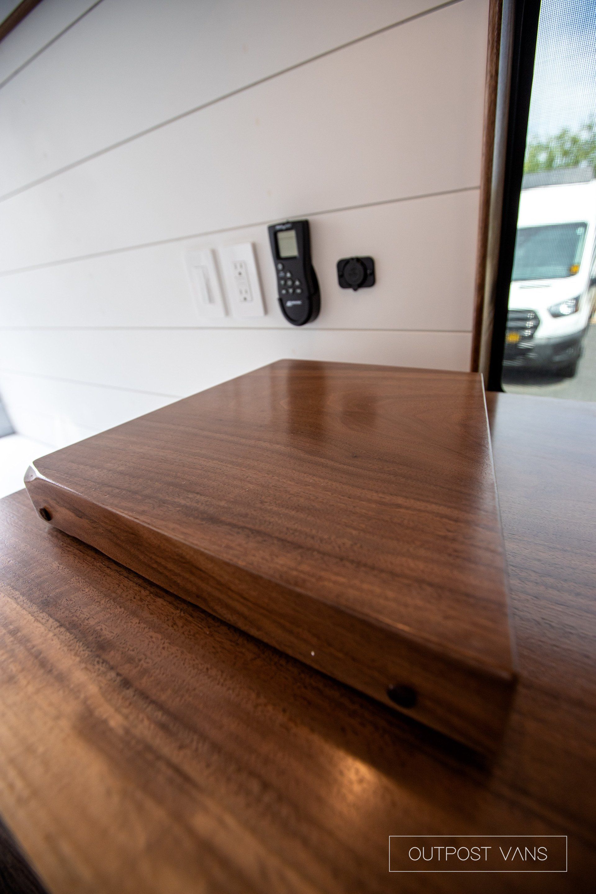 A wooden table with a remote control on it.